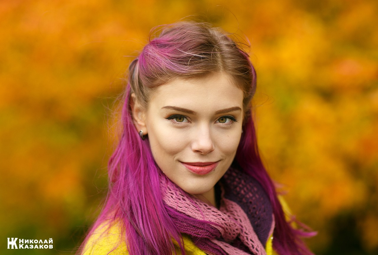Психологический портрет яркой девушки на фоне размытых желтых листьев