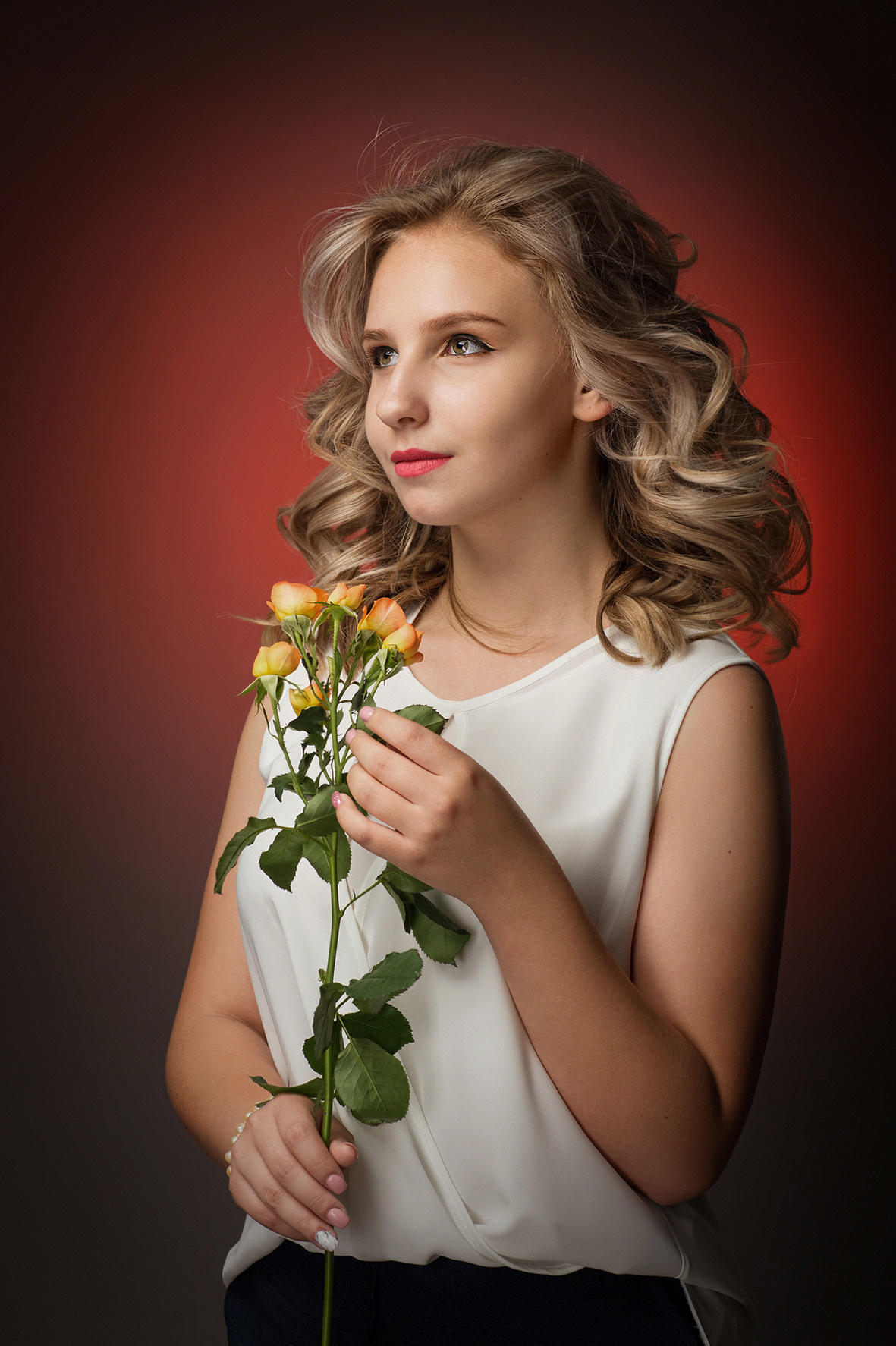 Портретная фотосессия в фотостудии на красном фоне.