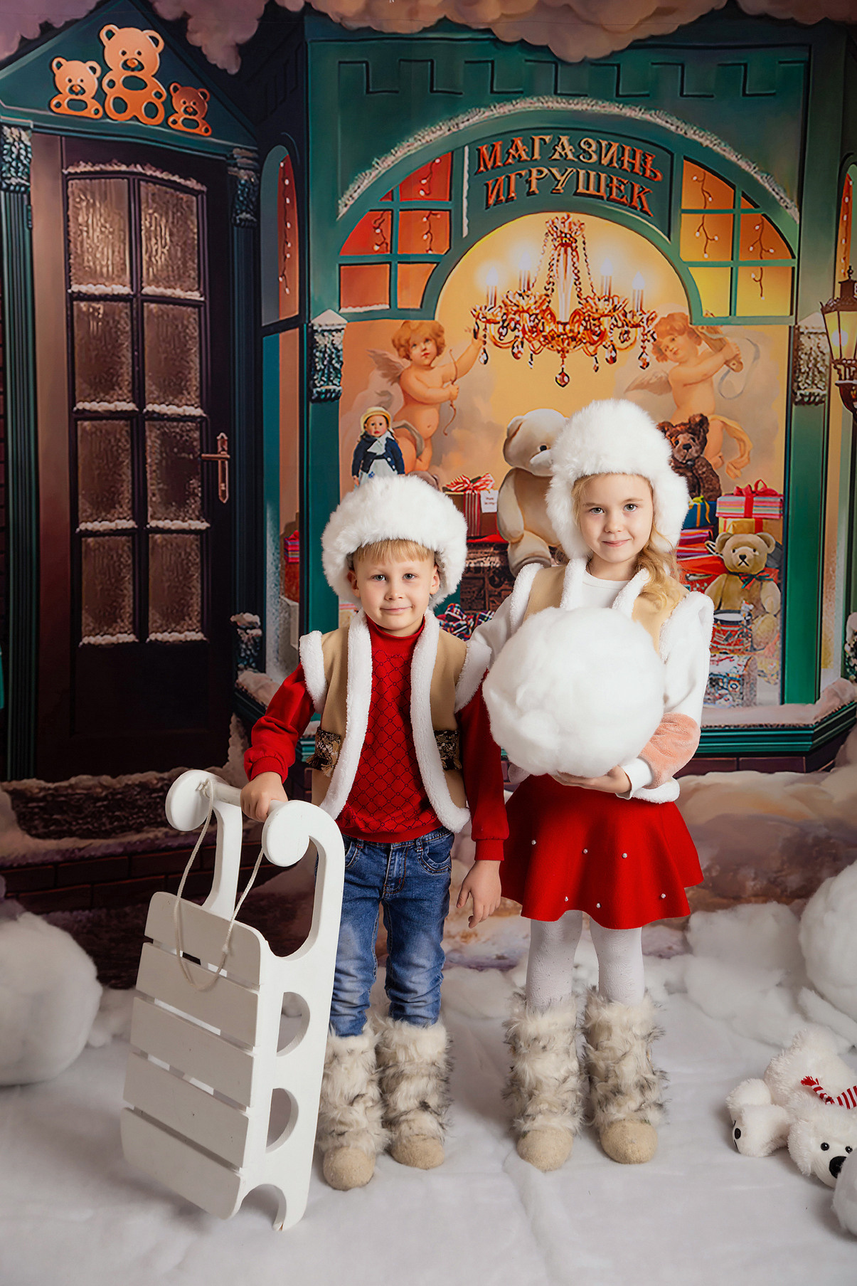 Тематическая выездная костюмированная фотосессия в детском саду на Новый год. Магазин игрушек. Девочка и мальчик с санками.