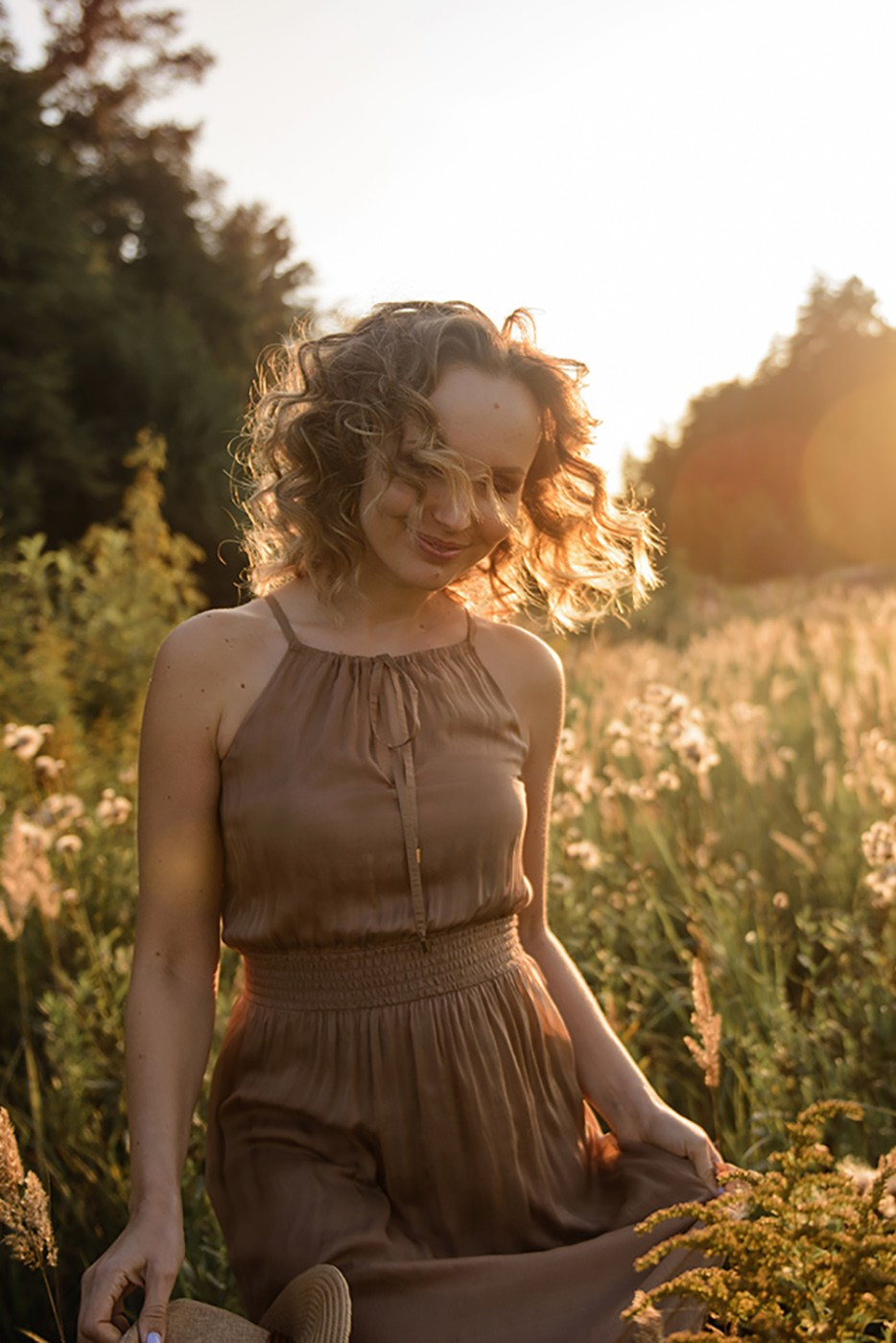 A photo shoot for a woman l in the field. Sunset photo shoot for a girl Curly hair style. (photographer in Edinburgh Elena)