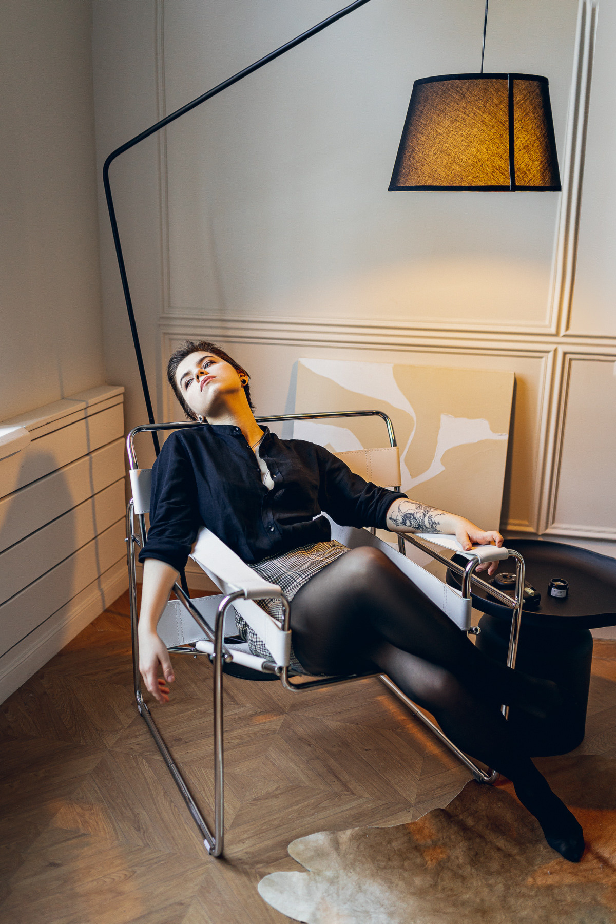 Профессиональная фотосессия в студии. Девушка на стуле под лампой.