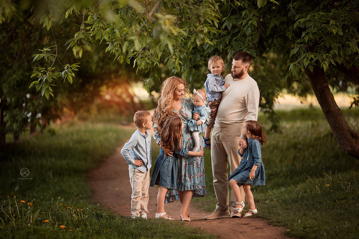 весёлая семья родители и дети в саду