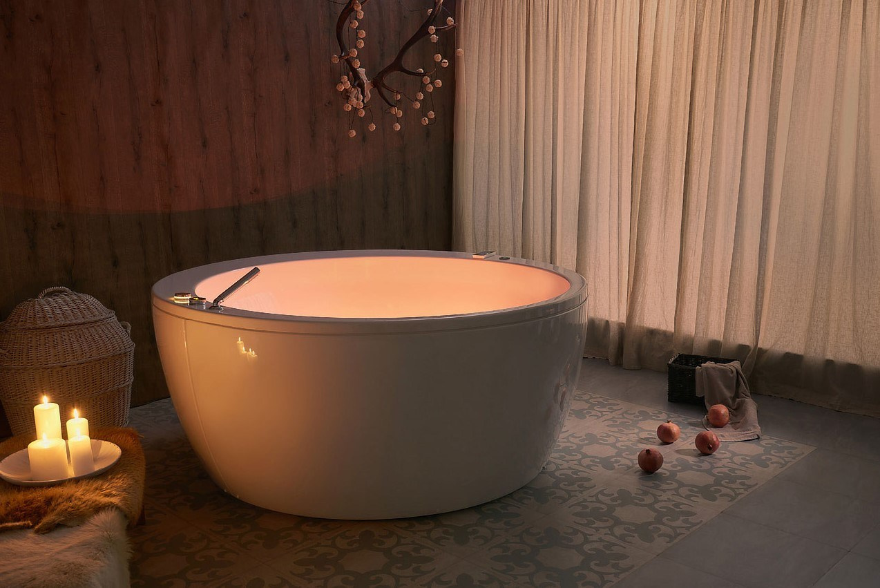 отдельно стоящая ванна при свечах в спокойном расслабляющем интерьере
