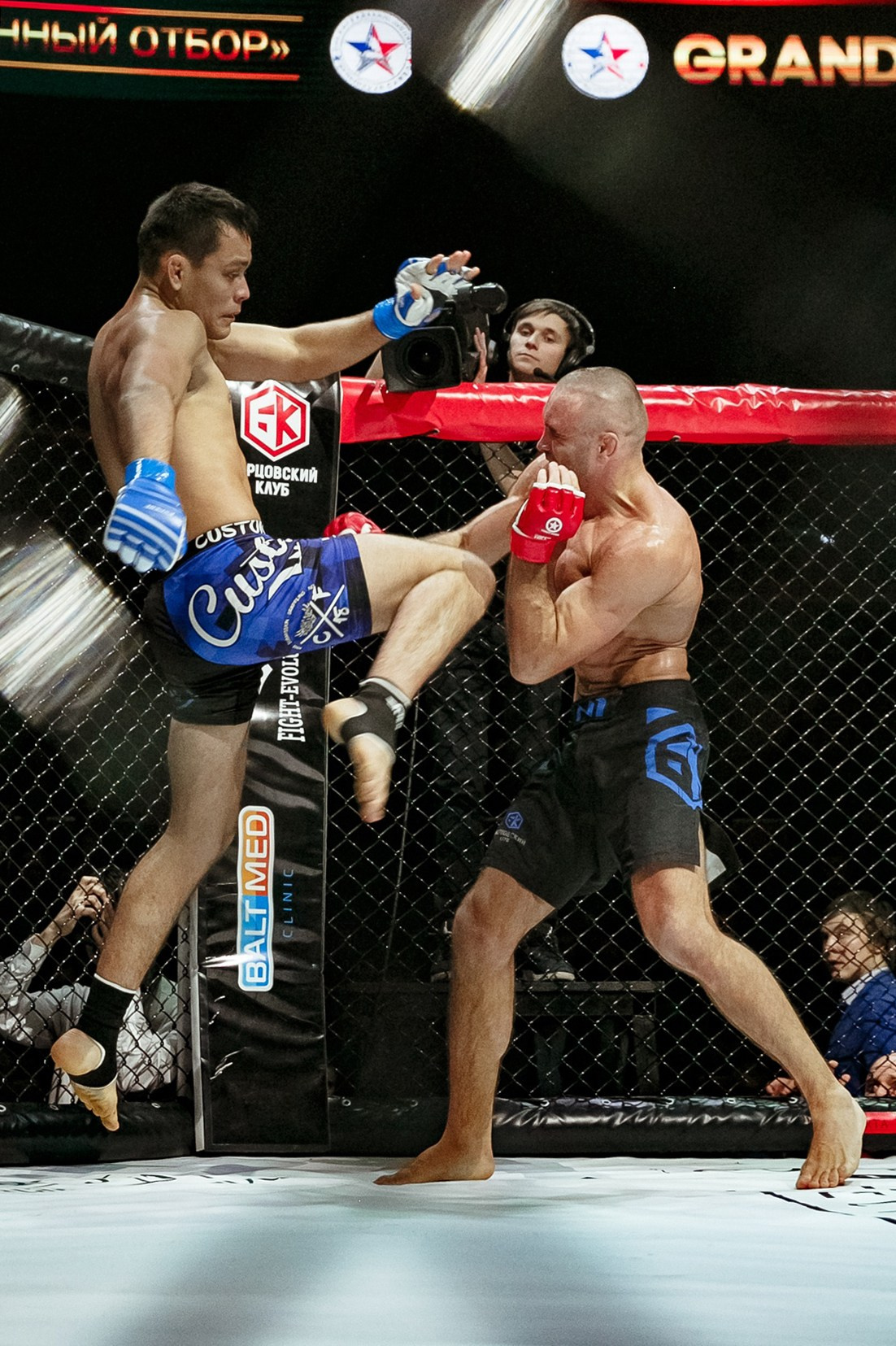 Блок удара коленом в воздухе в октагоне MMA репортажная фотография