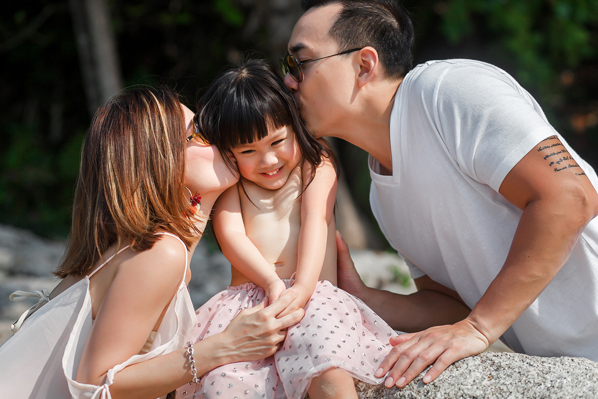 Couple from Singapore kissing them daughter on the Kamala beach