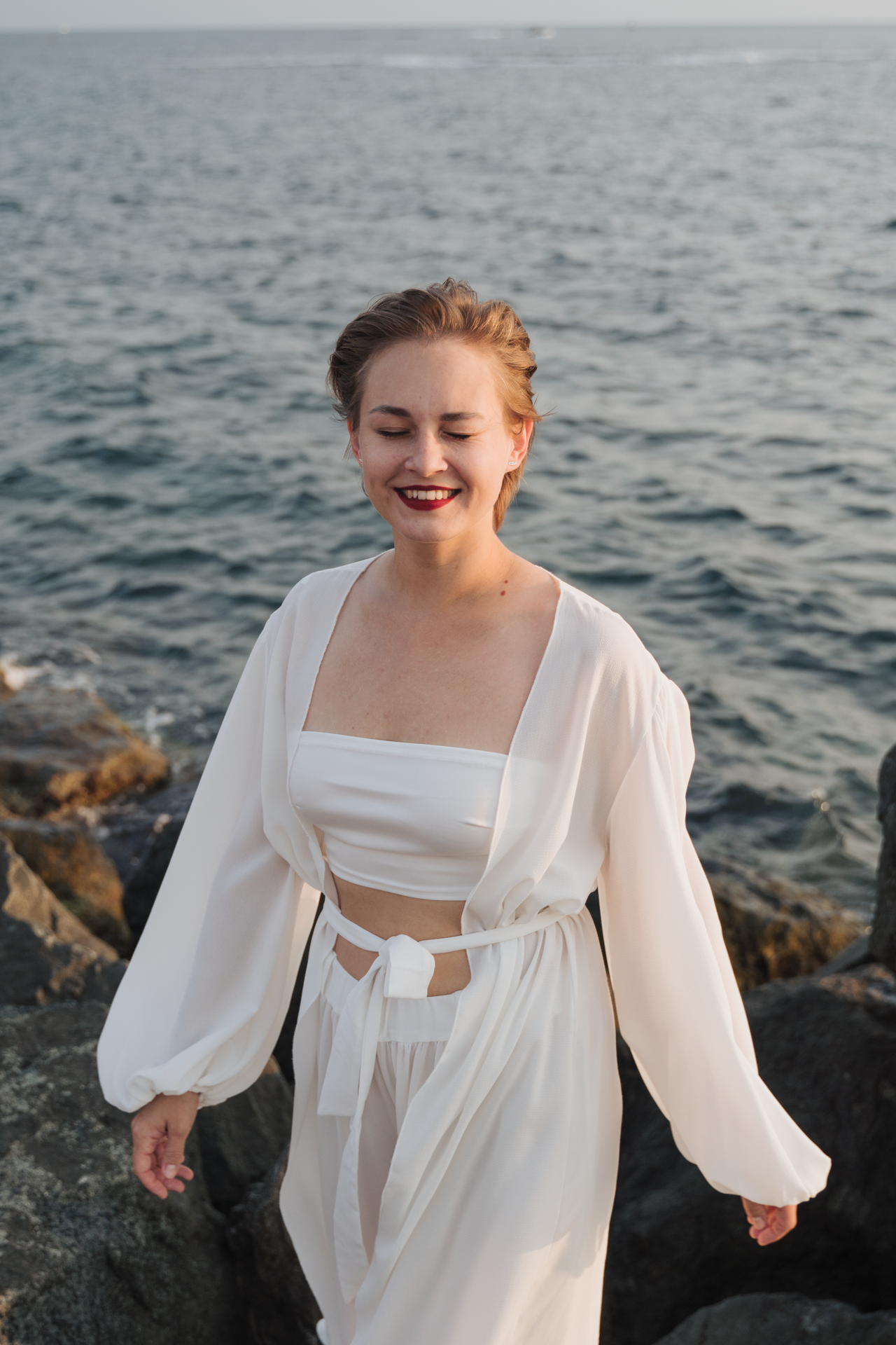 Снимок улыбающейся девушки на фоне моря