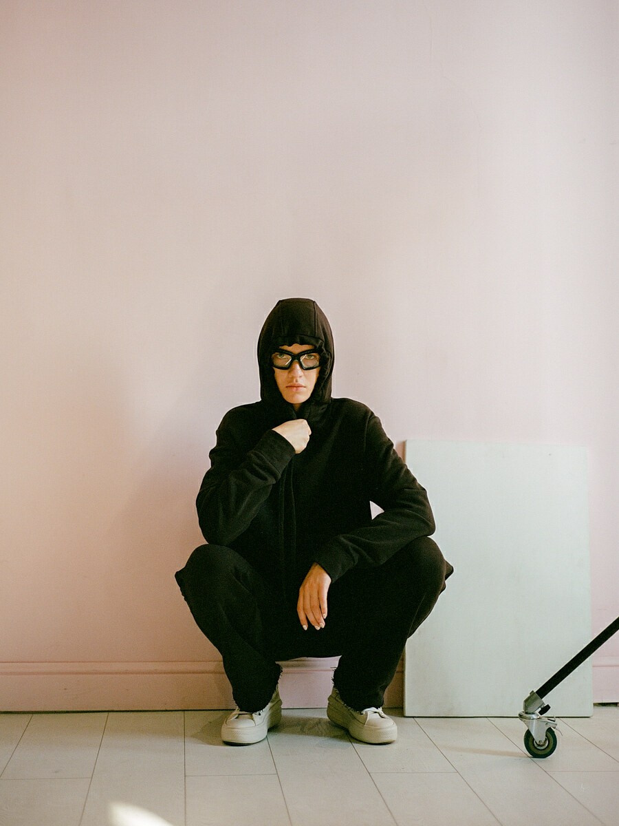 Fashion-съёмка спортивной одежды в минималистичном интерьере, розовый фон