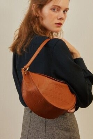 Идея для женской сумки с декоративными строчками и глянцевым покрытием.