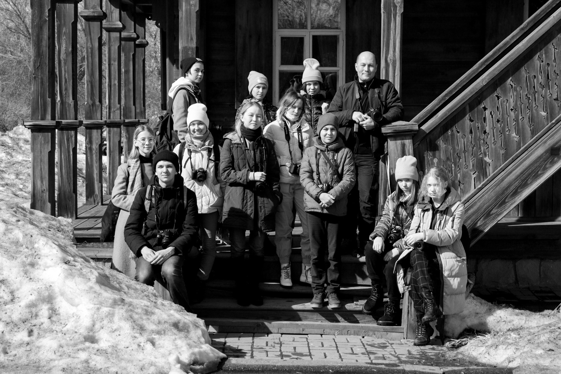 Интересное место - повод сделать групповое фото. Ученики фотошколы вместе позируют у деревянного здания музея.