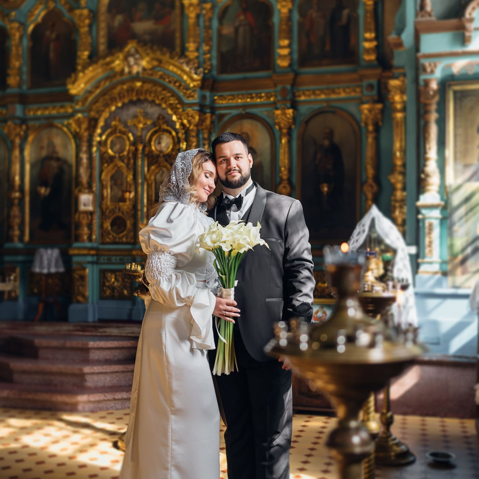 Молодожёны после православного венчания в храме с букетом