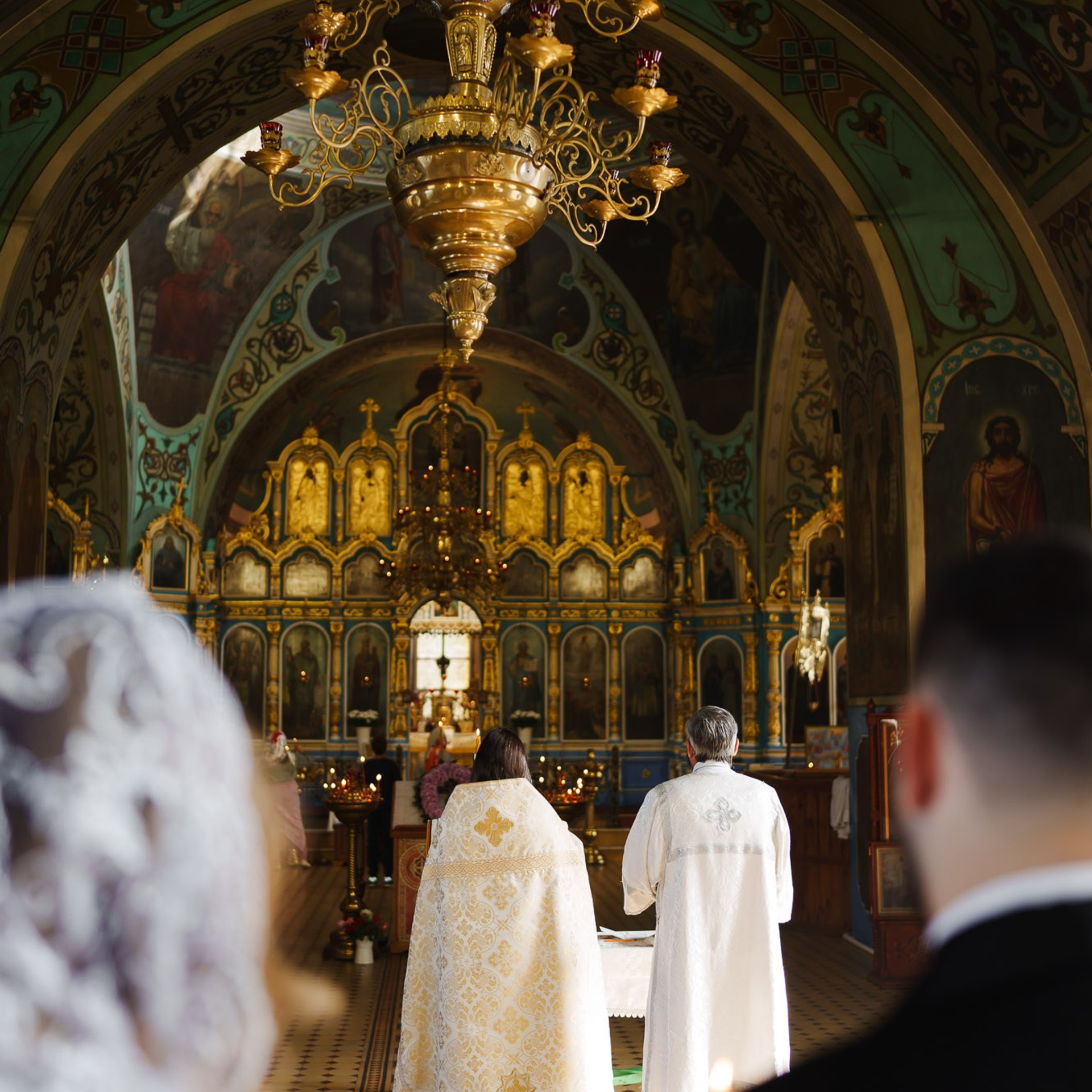 Православное венчание в храме, священник и пара перед иконостасом