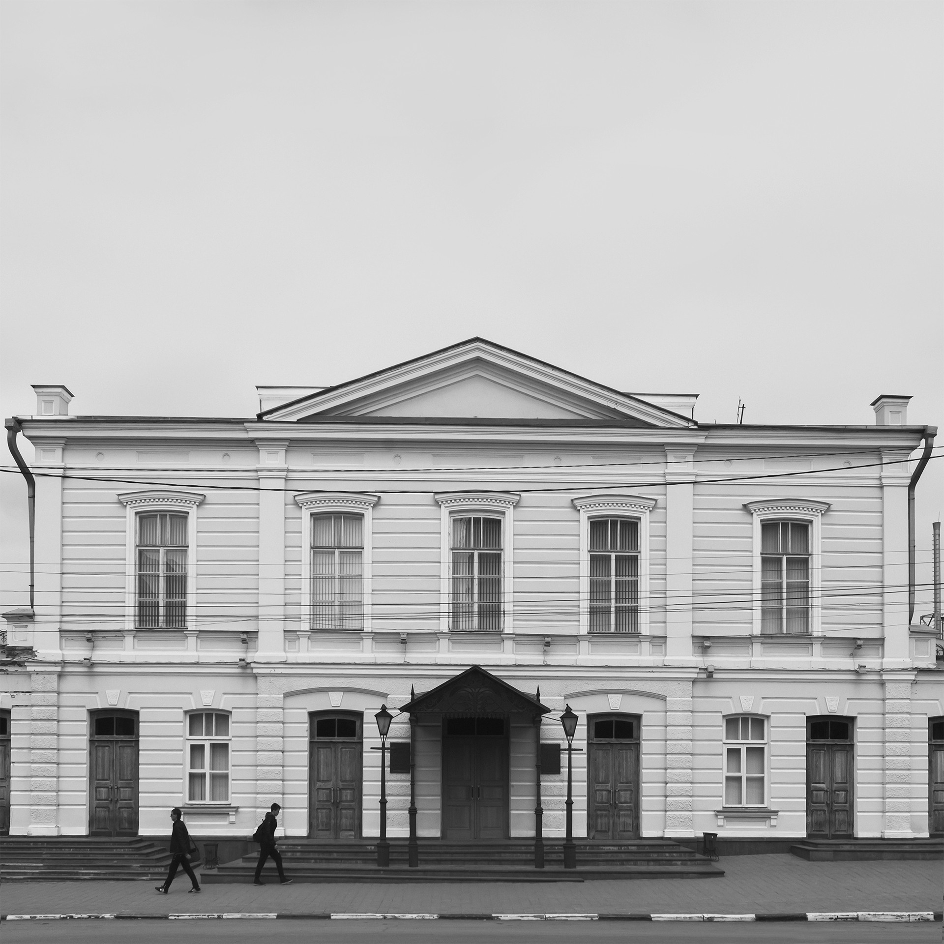 Фотография Таганрогского драматического театра имени А.П. Чехова, расположенного в городе Таганрог. Здание театра в стиле неоклассицизма было построено в начале XX века и является культурным наследием региона. На фото запечатлен фасад здания с улицы