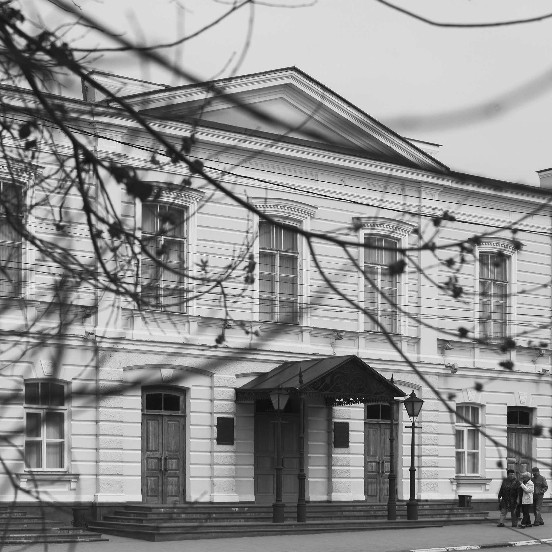 Фотография Таганрогского драматического театра имени А.П. Чехова, расположенного в городе Таганрог. Здание театра в стиле неоклассицизма было построено в начале XX века и является культурным наследием региона. На фото запечатлен фасад здания с улицы.