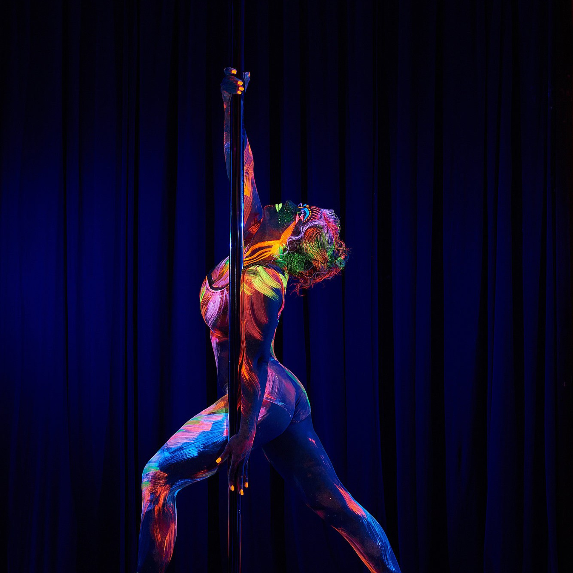 Танцовщица в фиолетово-синем свете выполняет вытянутую диагональную линию тела, создавая ощущение парения и сценической глубины. Художественная танцевальная фотография, Москва и Истринский район.