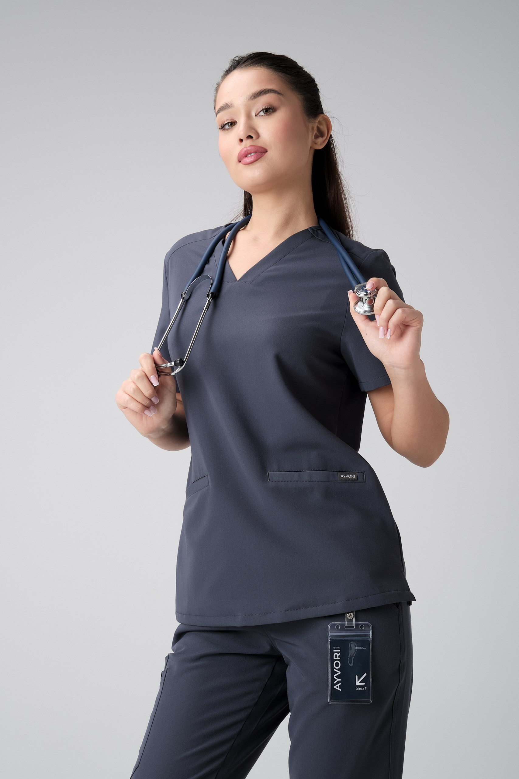 Модель в тёмной медицинской форме со стетоскопом — лукбук съёмка медицинской одежды премиум-класса