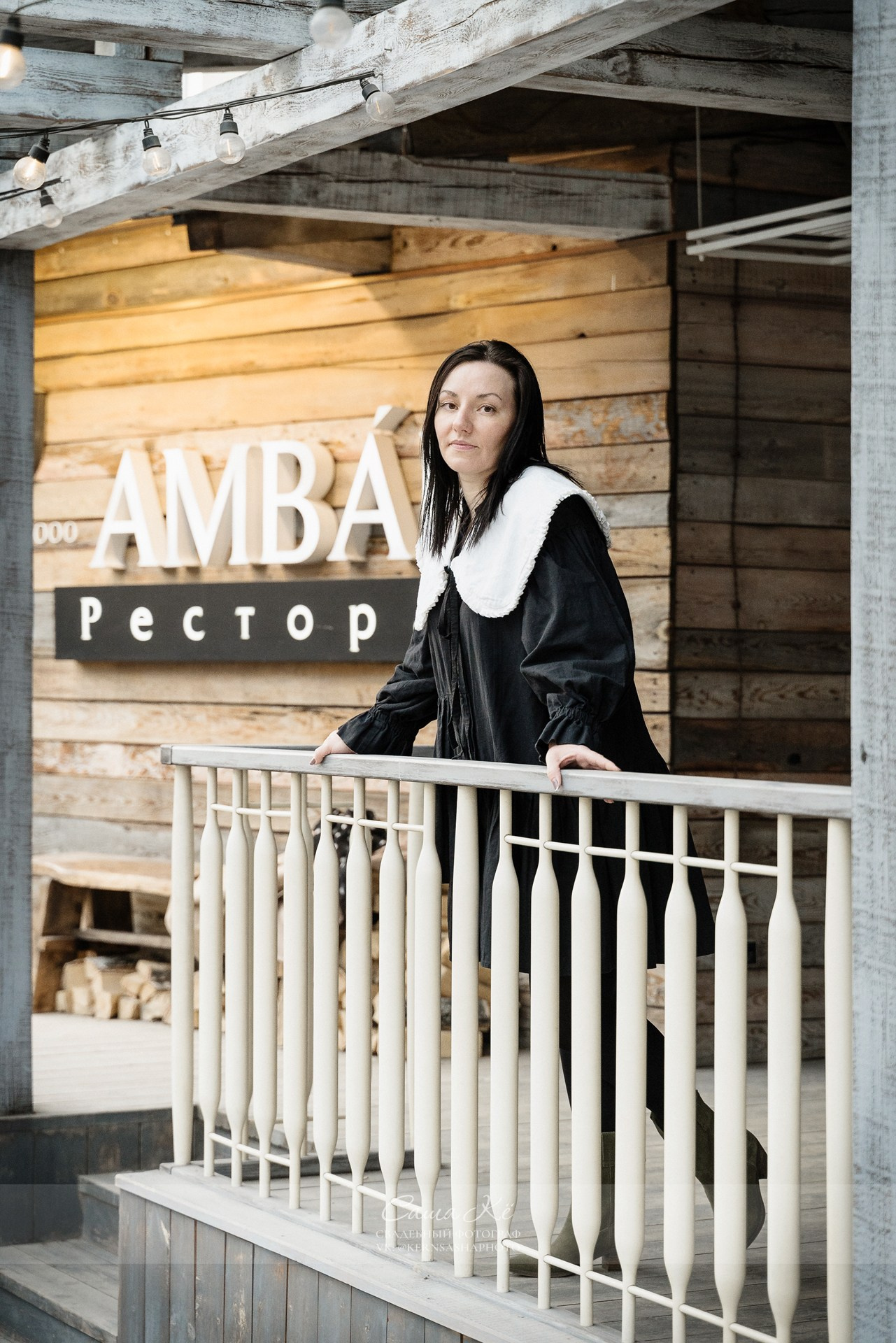Акцент на ювелирных украшениях на женщине в чёрном платье.