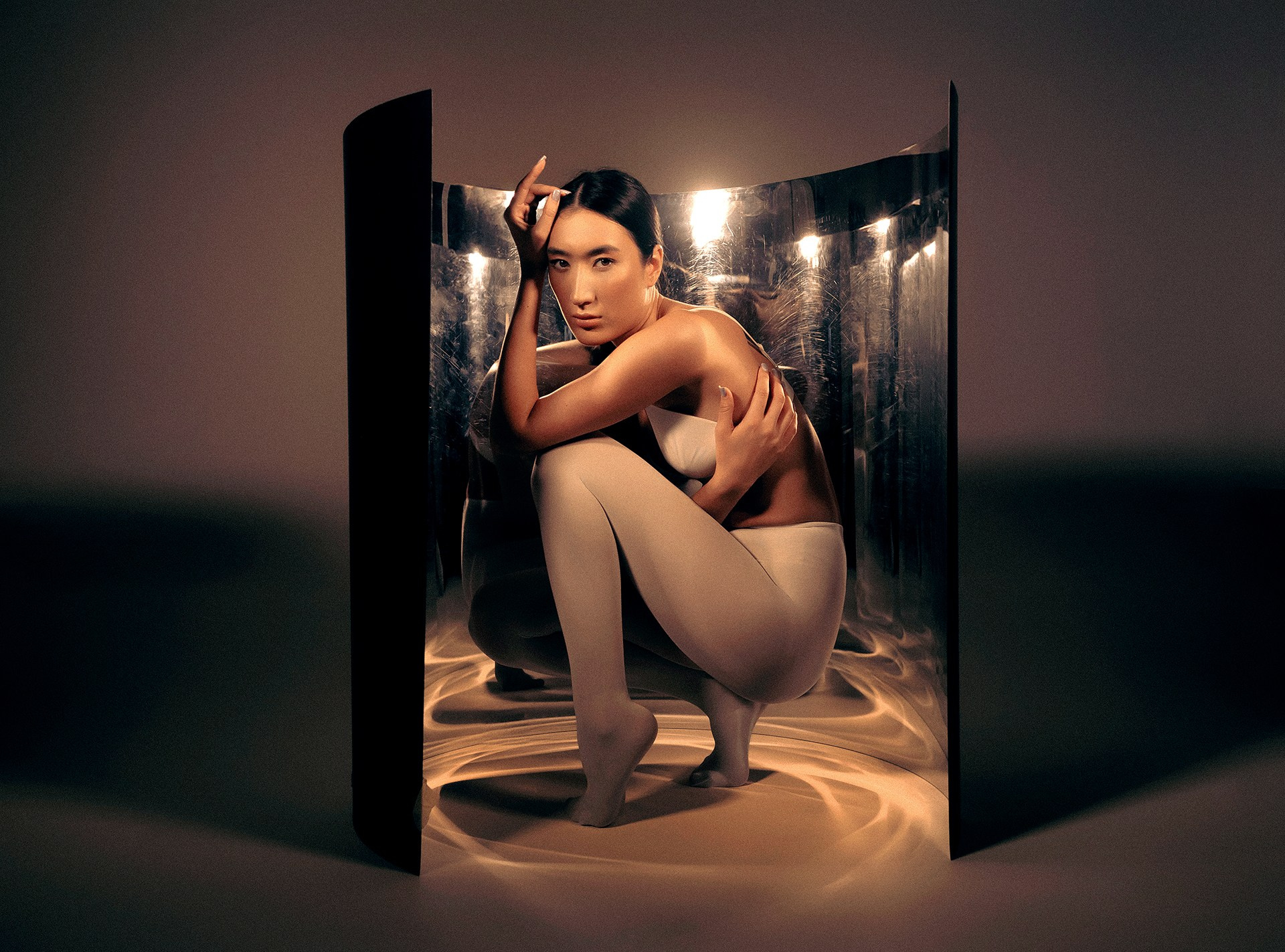 Съемка с гибким зеркалом Казань, девушка позирует в фотостудии на циклораме вокруг нее стоит гибкое зеркало