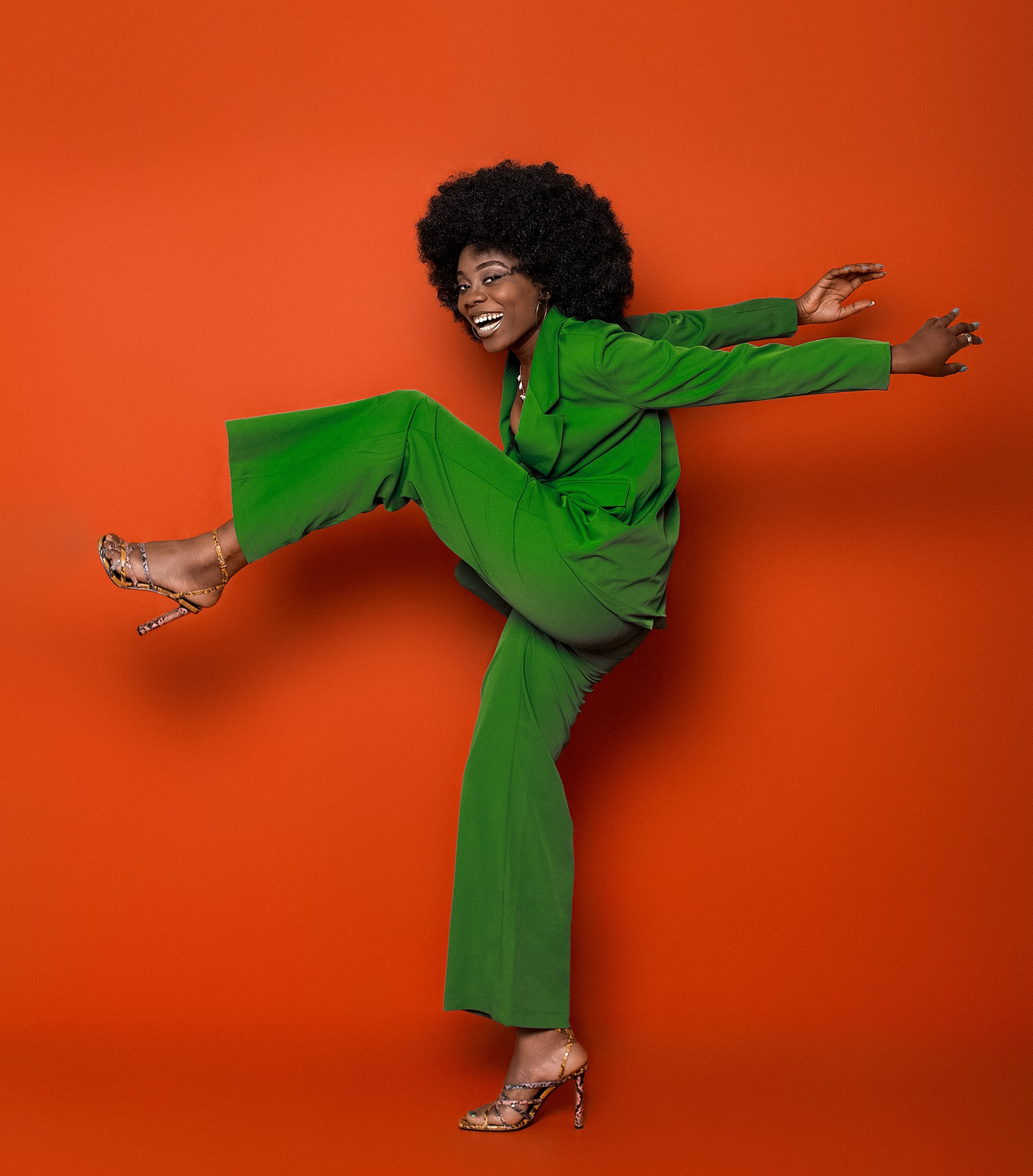 Фэшн на красном фоне Казань, темнокожая девушка в зеленом пиджаке позирует на красном фоне в фотостудии