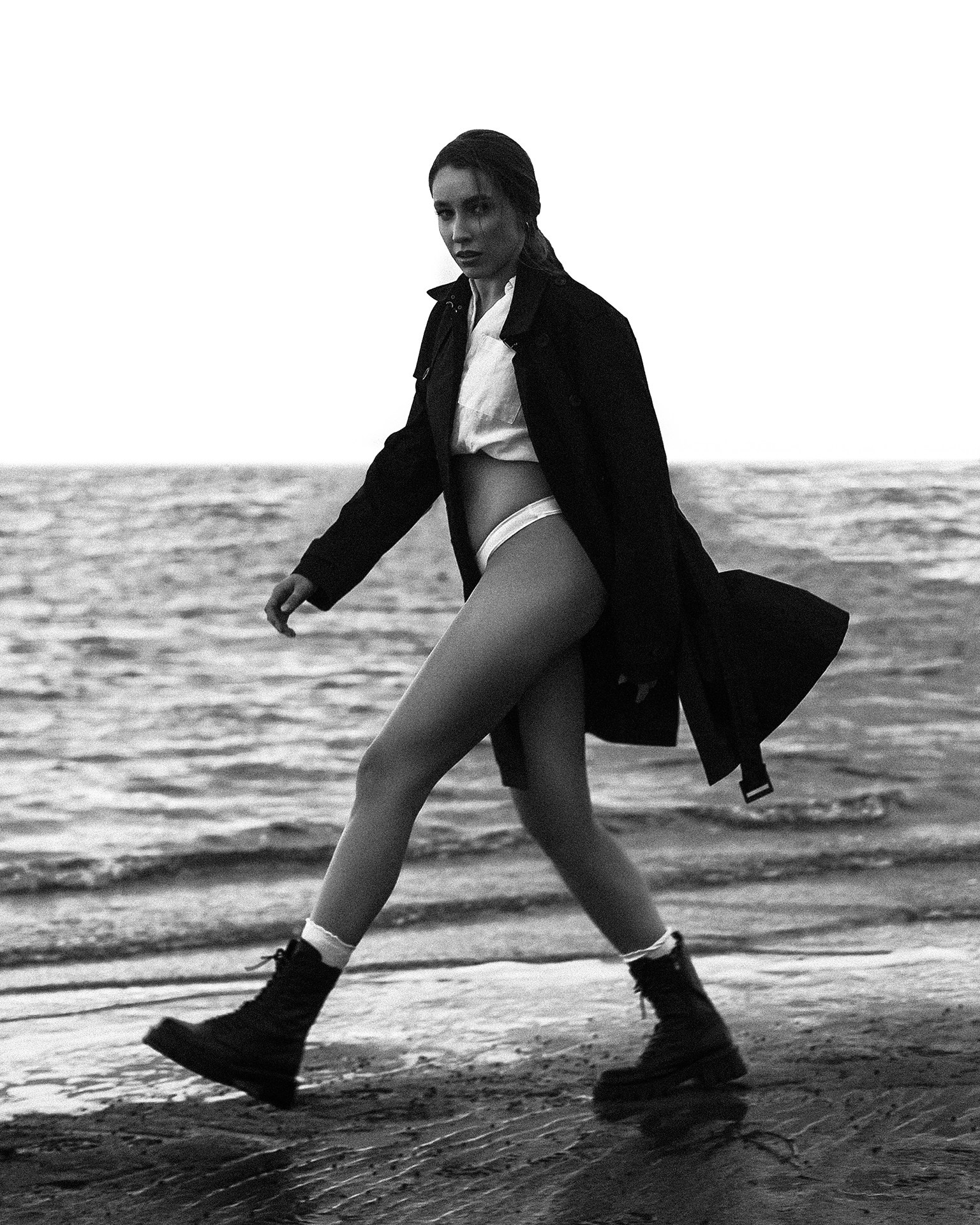 Уличная съемка модели в пальто и в белье на берегу моря