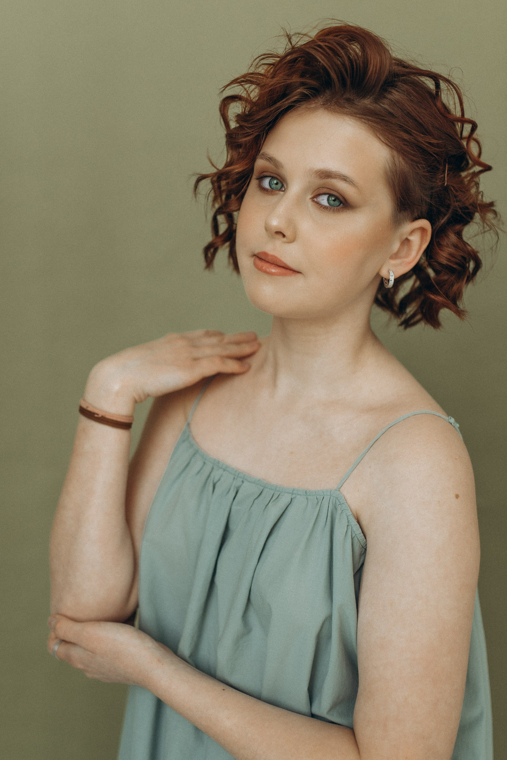 Портрет девушки с рыжими волосами на оливковом фоне. Крупный план, естественный макияж и мягкий студийный свет. Фотограф Василий Дан