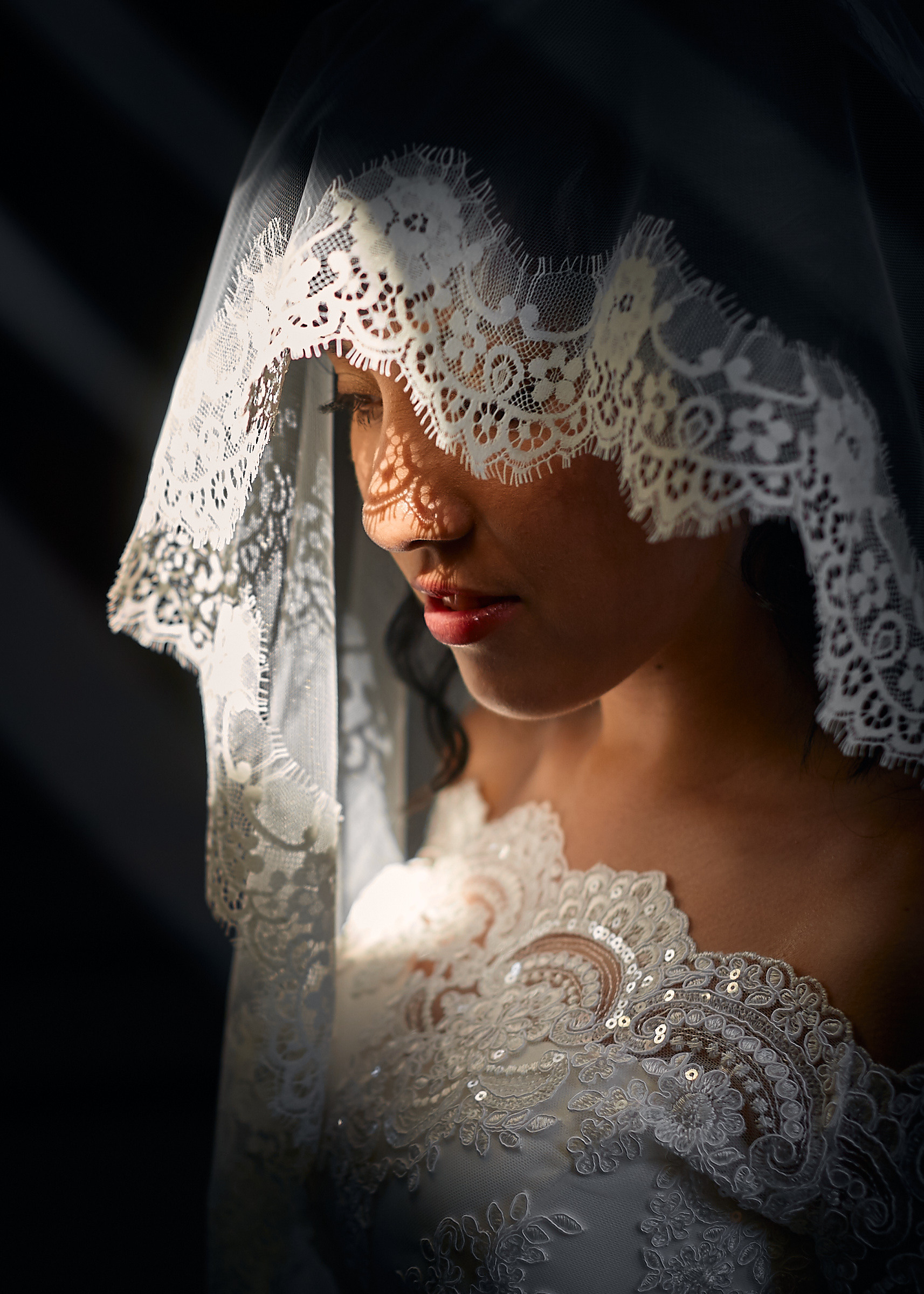 Невеста с длинной фатой на лице, в церкви опустила глаза