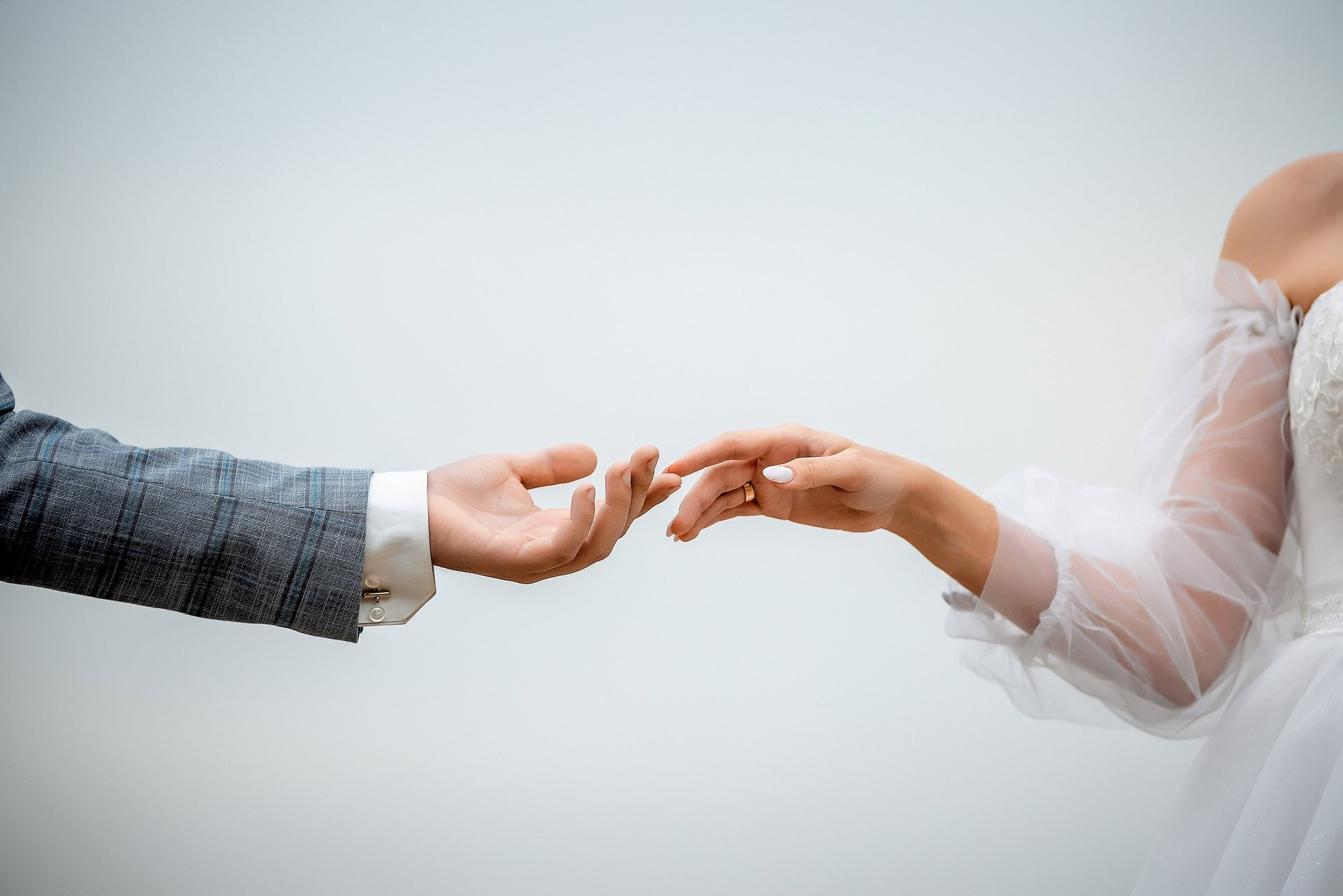 Руки жениха и невесты на фоне неба,