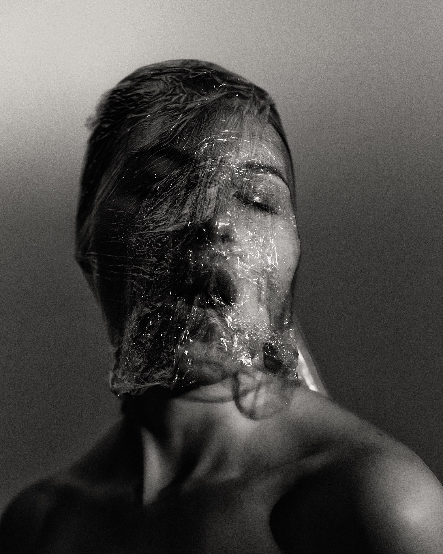 Съемка молодой девушки с пищевой пленкой, девушка в пищевой пленке крупный портрет