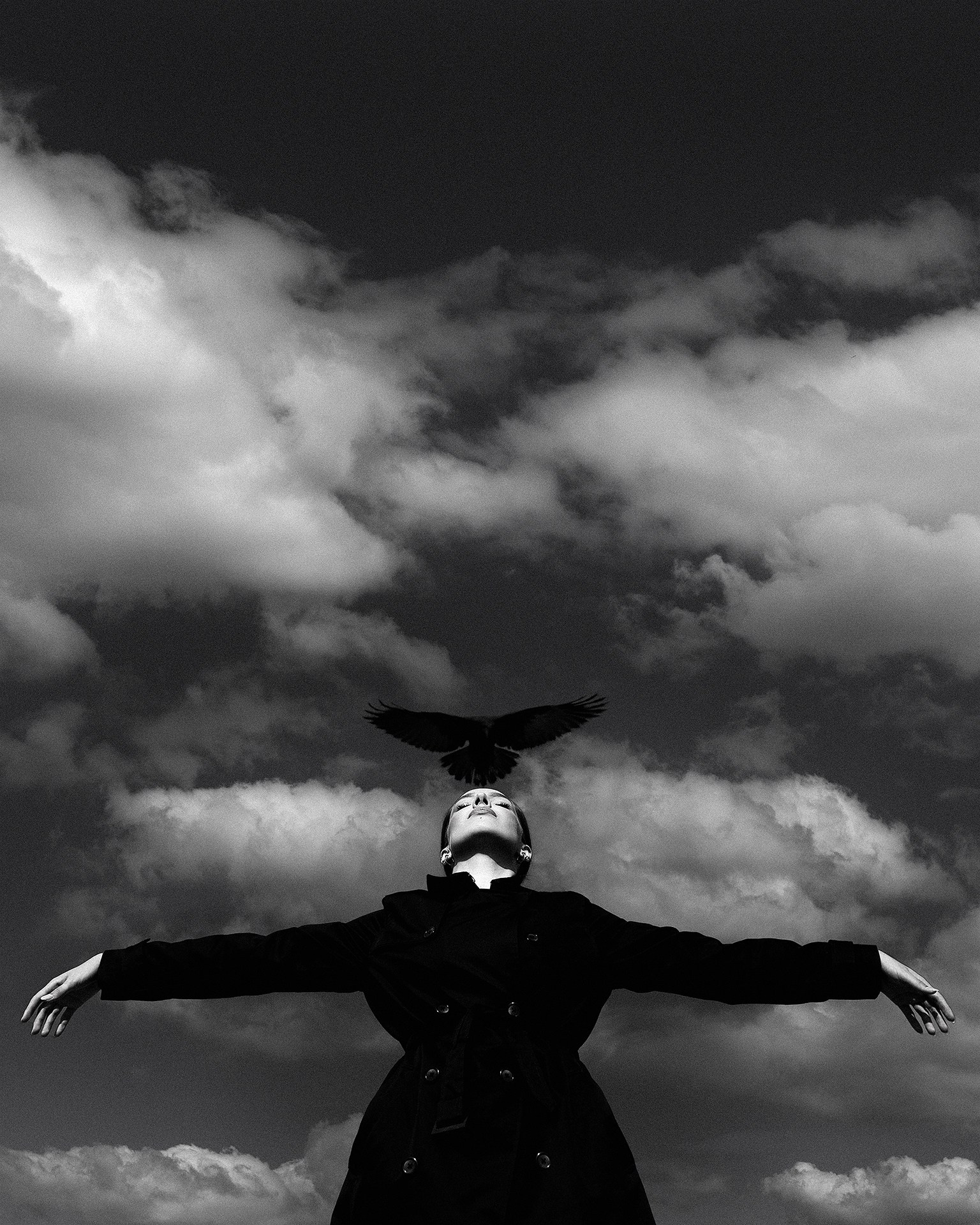 Молодая девушка стоит на фоне неба с пальто с открытой позе