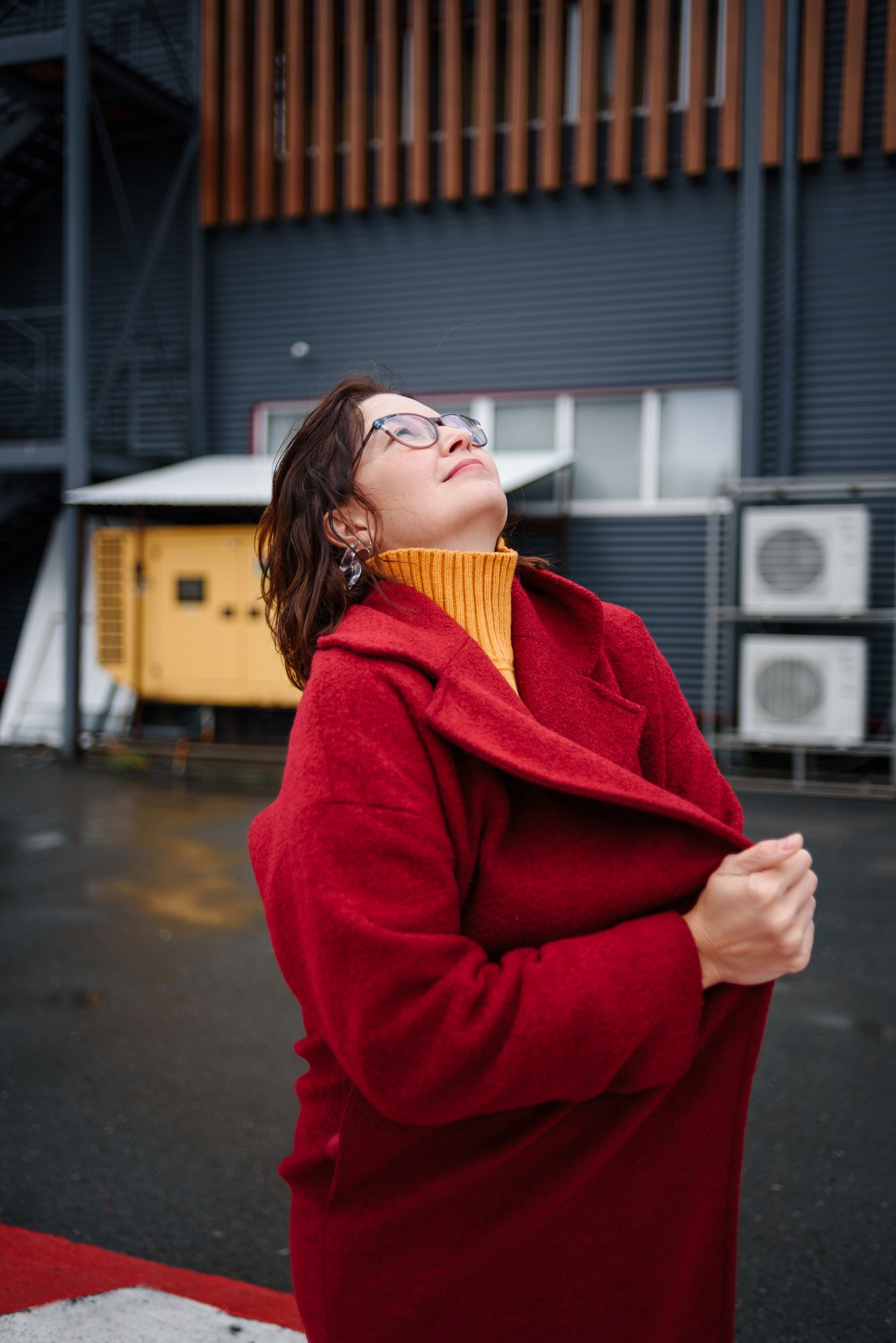 Женский портрет в полный рост на фоне лаконичных фасадов зданий