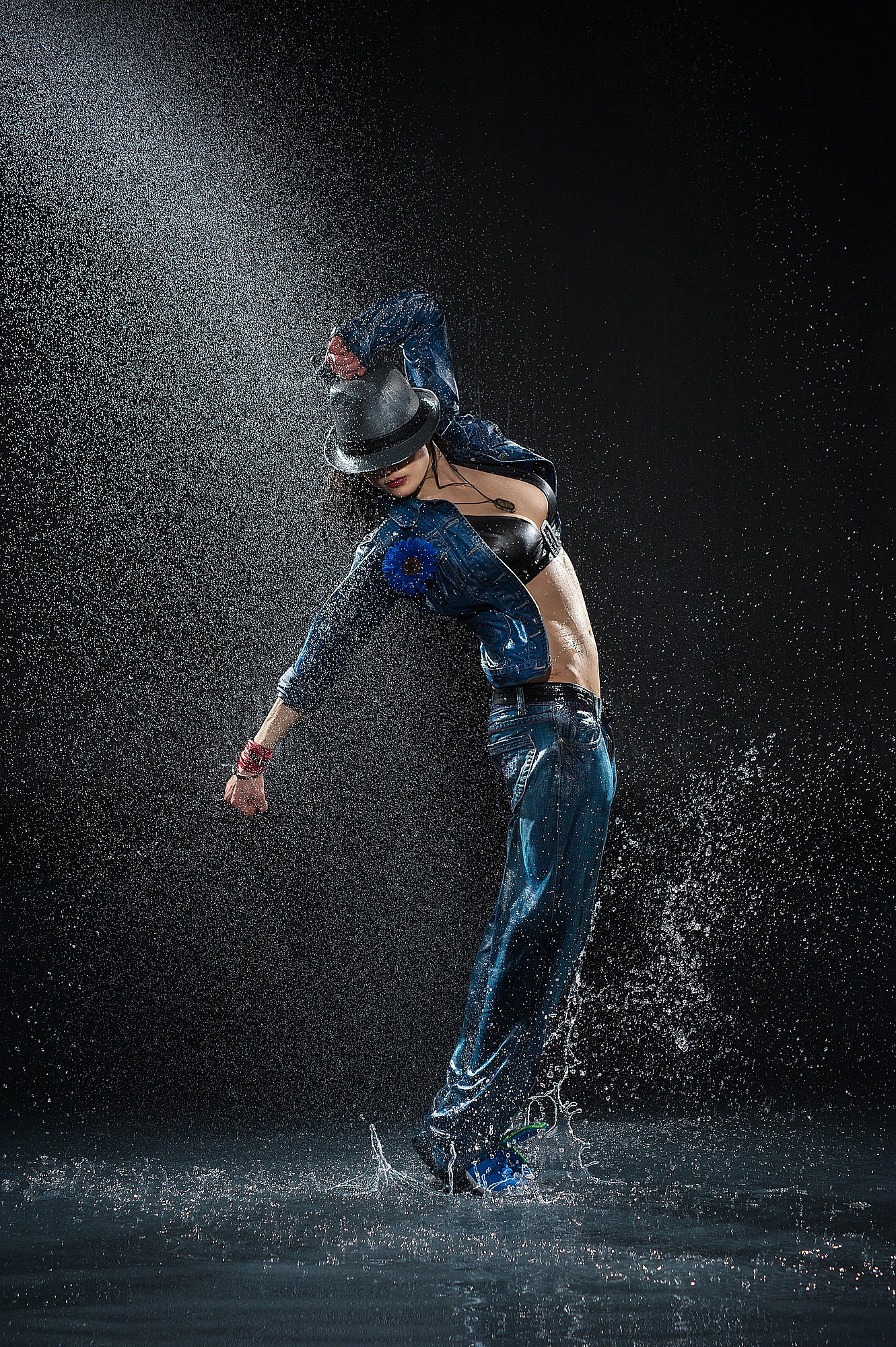 Стрит-танцор выполняет фирменный наклон в стиле Майкла Джексона под мощным дождевым потоком. Динамическая танцевальная фотосъёмка с водными эффектами в Москве и Истринском районе.