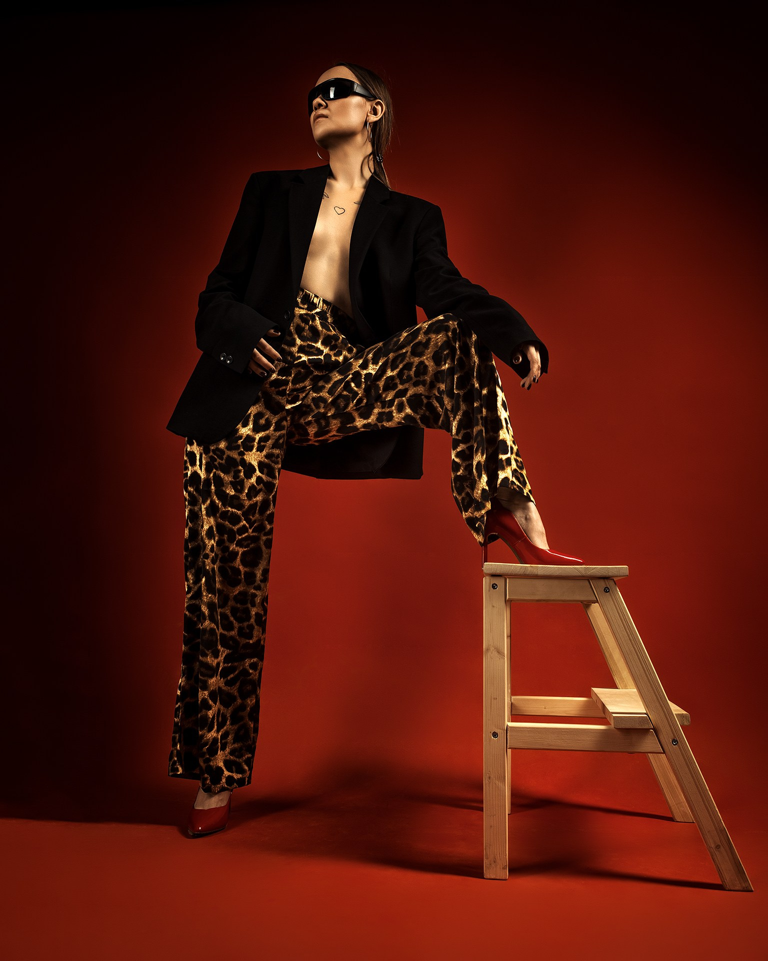 съемка модели в леопардовых штанах и черном пиджаке на красном фоне Казань