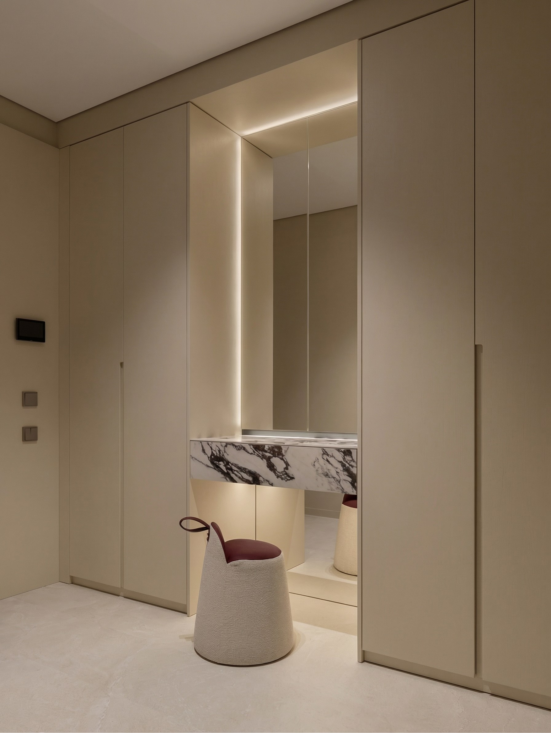 Дизайн гардеробной зоны от Валерии Котович: встроенные шкафы в потолок, парящий туалетный столик из камня и архитектурная подсветка зеркала.