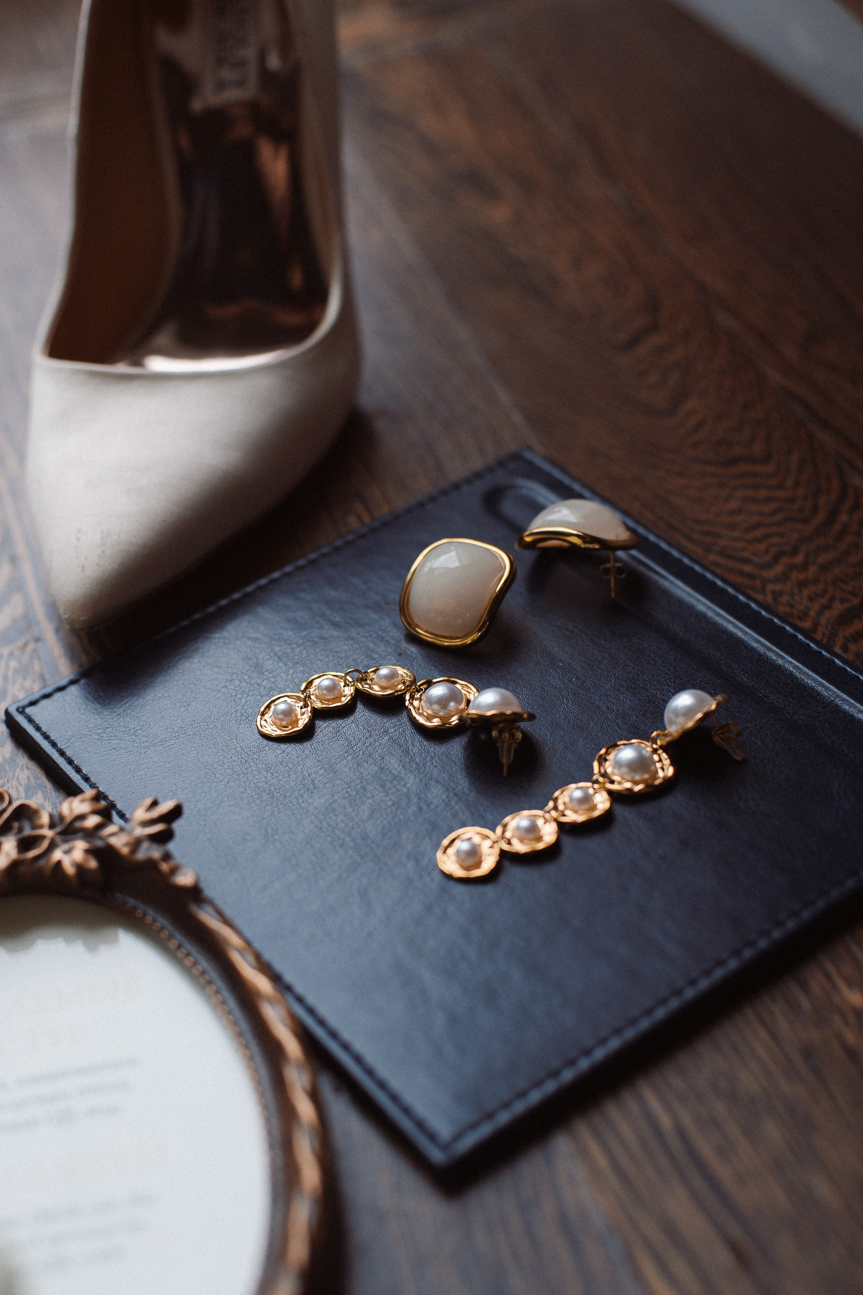 Цветная фотография свадебных деталей: украшения и туфли на деревянном столе — подготовка в Trezzini Palace Hotel, Санкт-Петербург