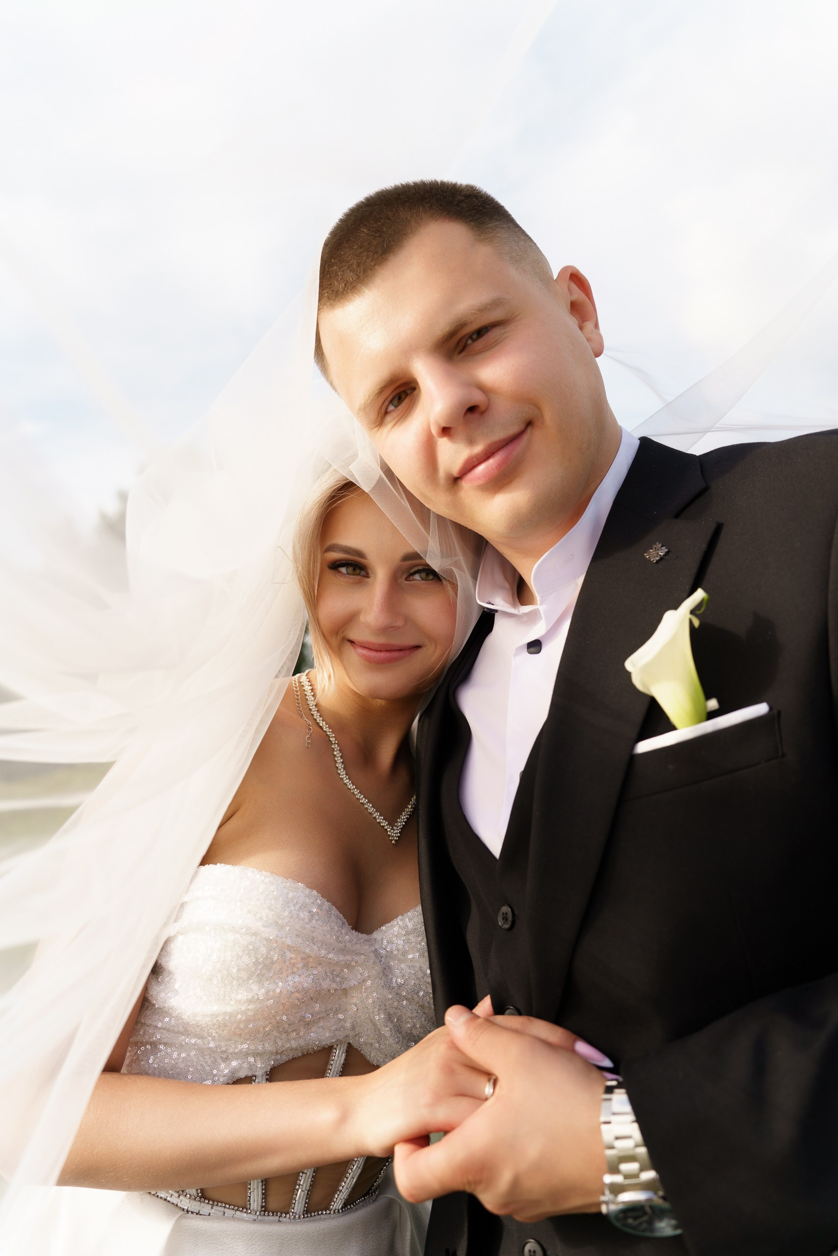 Нежность в каждом прикосновении: жених держит руку невесты, а её сверкающее платье и лёгкая фата создают ощущение сказочного волшебства | фотограф Екатеринбург