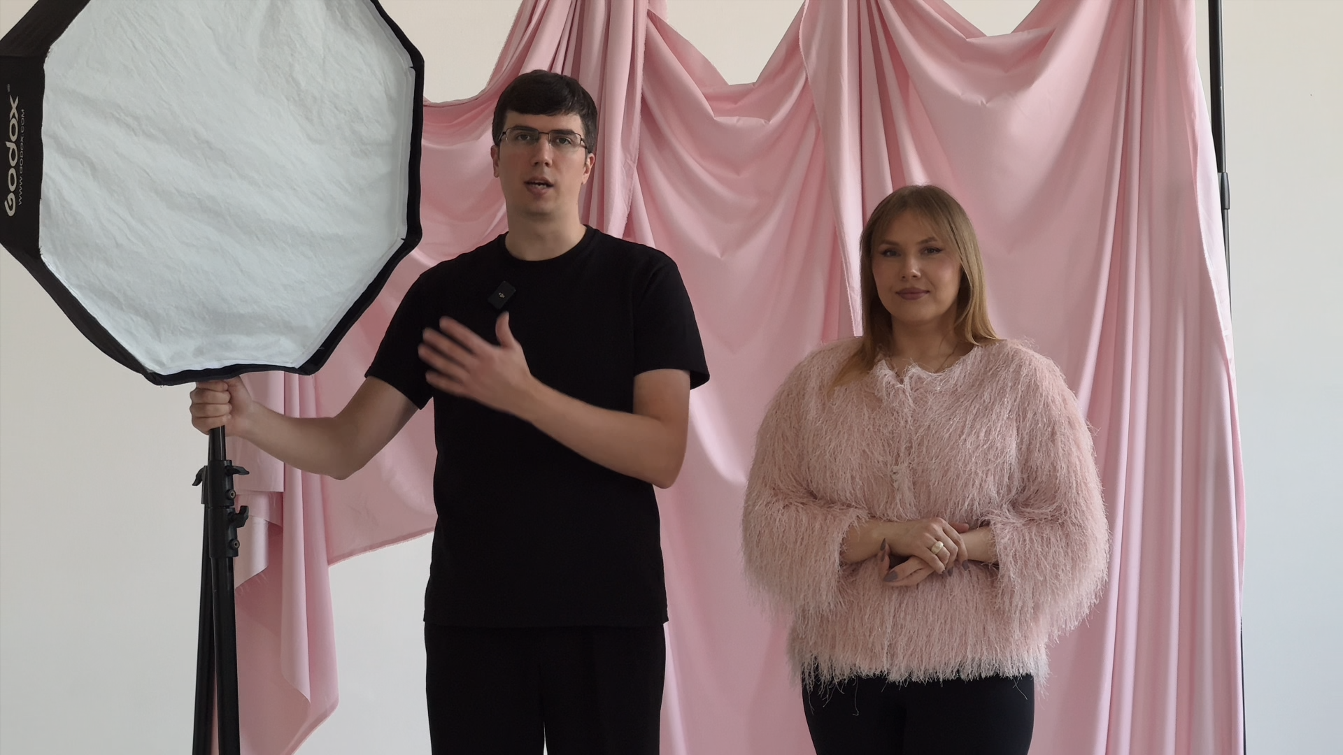 Постановка света на фотозоне: преподаватель демонстрирует расположение октобокса рядом с моделью на фоне розовой драпировки.