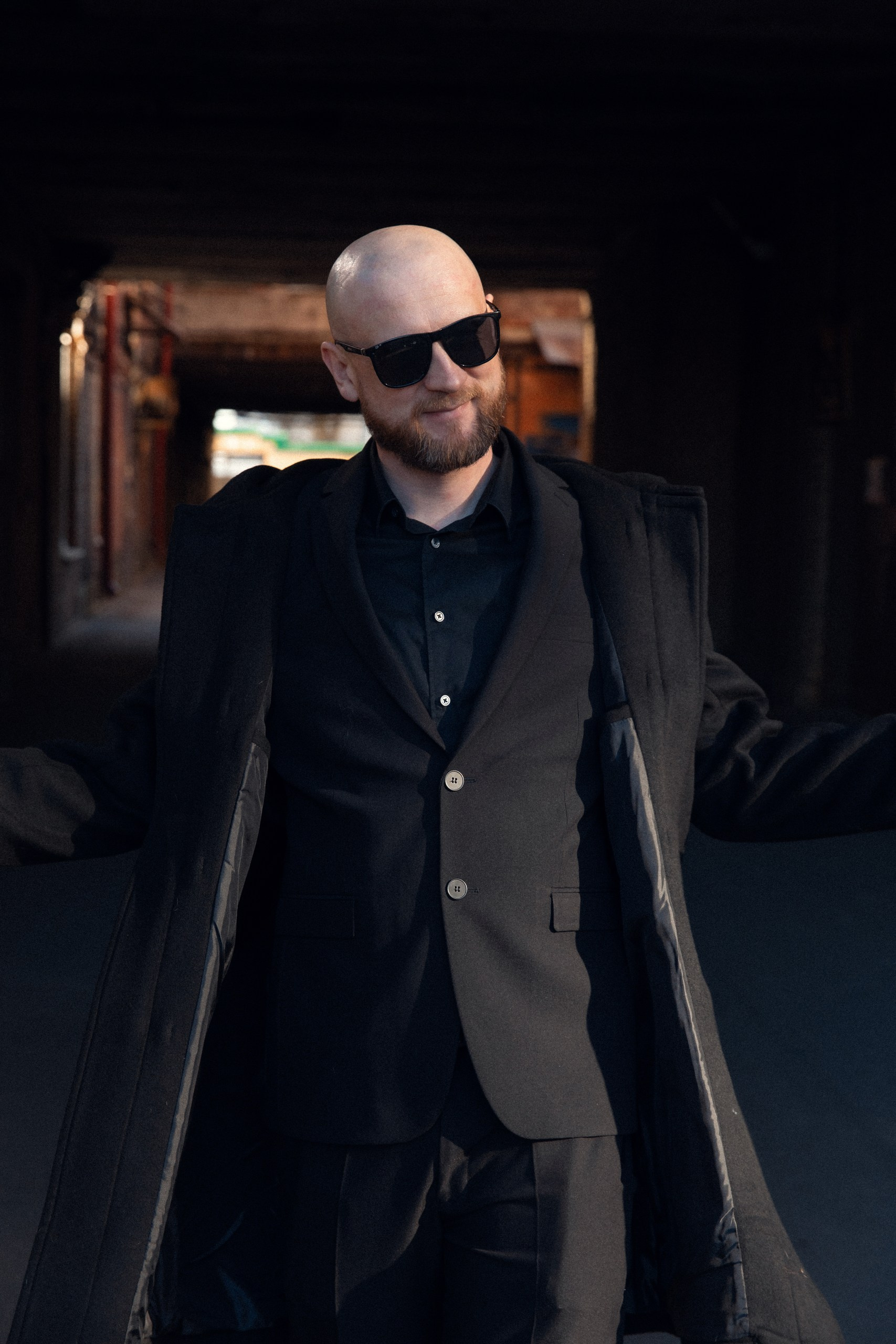 Мужчина в очках позирует в проходе исторического здания, стильный портрет от фотографа в Санкт-Петербурге..