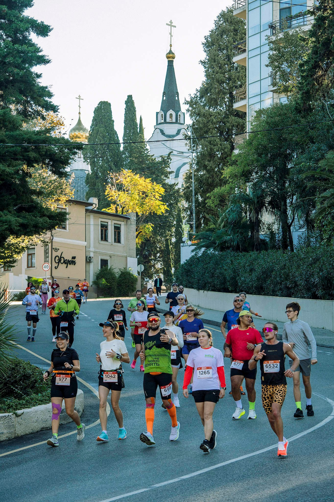 Люди бегут на фоне собора Архангела Михаила в Сочи