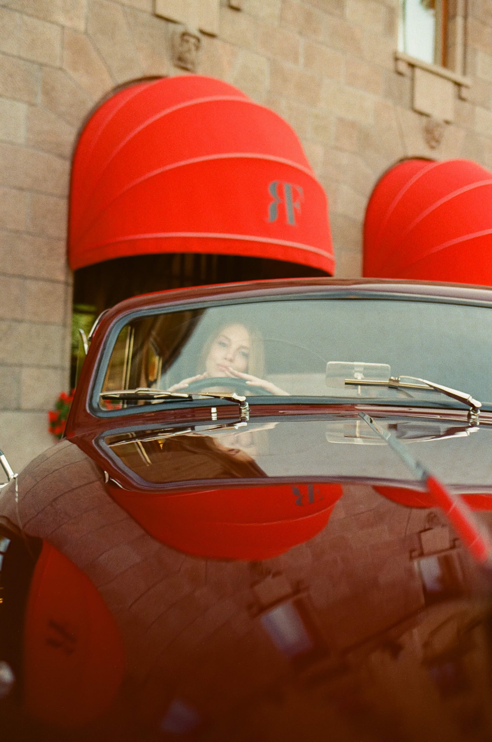Невеста за рулём ретро автомобиля Jaguar 1959 года во время свадебной фотосессии.