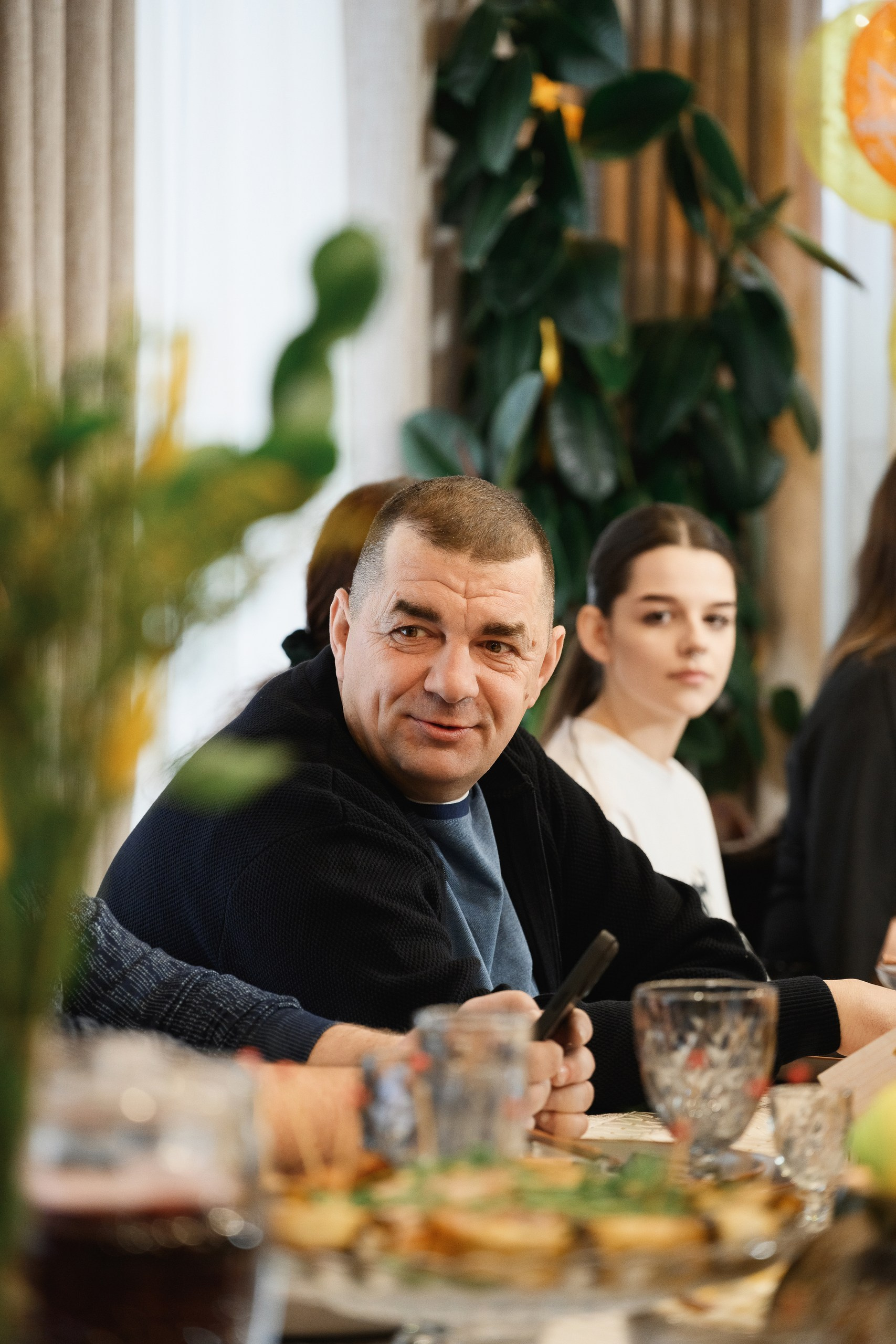 Мужчина за праздничным столом на семейном мероприятии, естественный свет и репортажный стиль съёмки, Петропавловск-Камчатский.