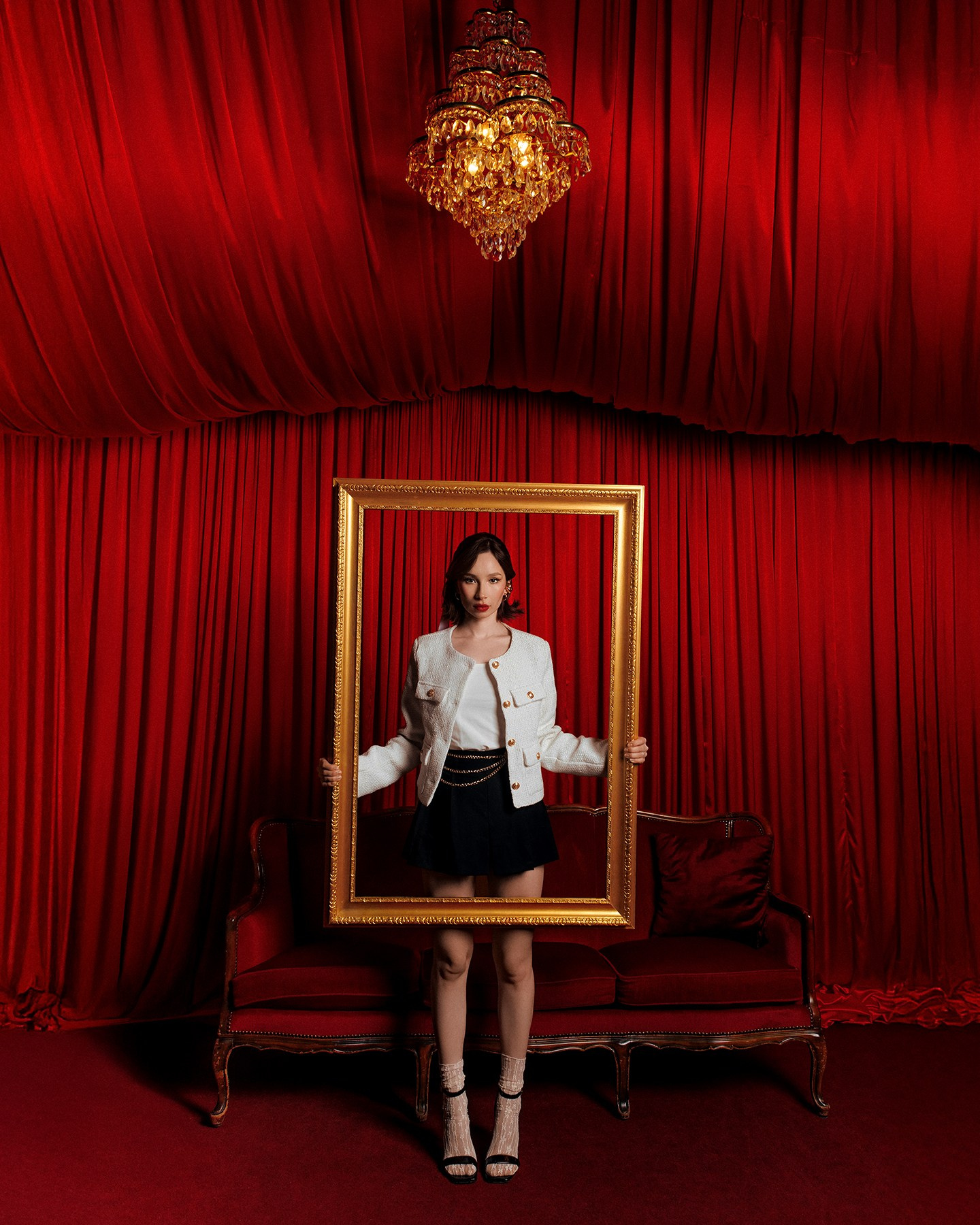 Съемка с картинной рамкой на фоне красных штор в студии Казань