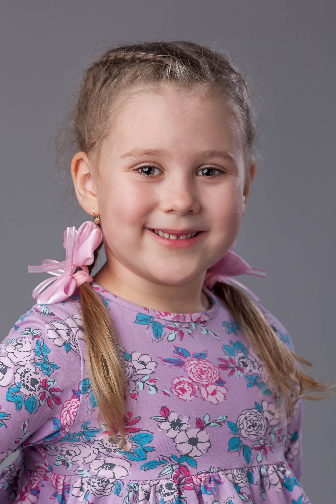 Портрет выпускницы детского сада на сером фоне по грудь.