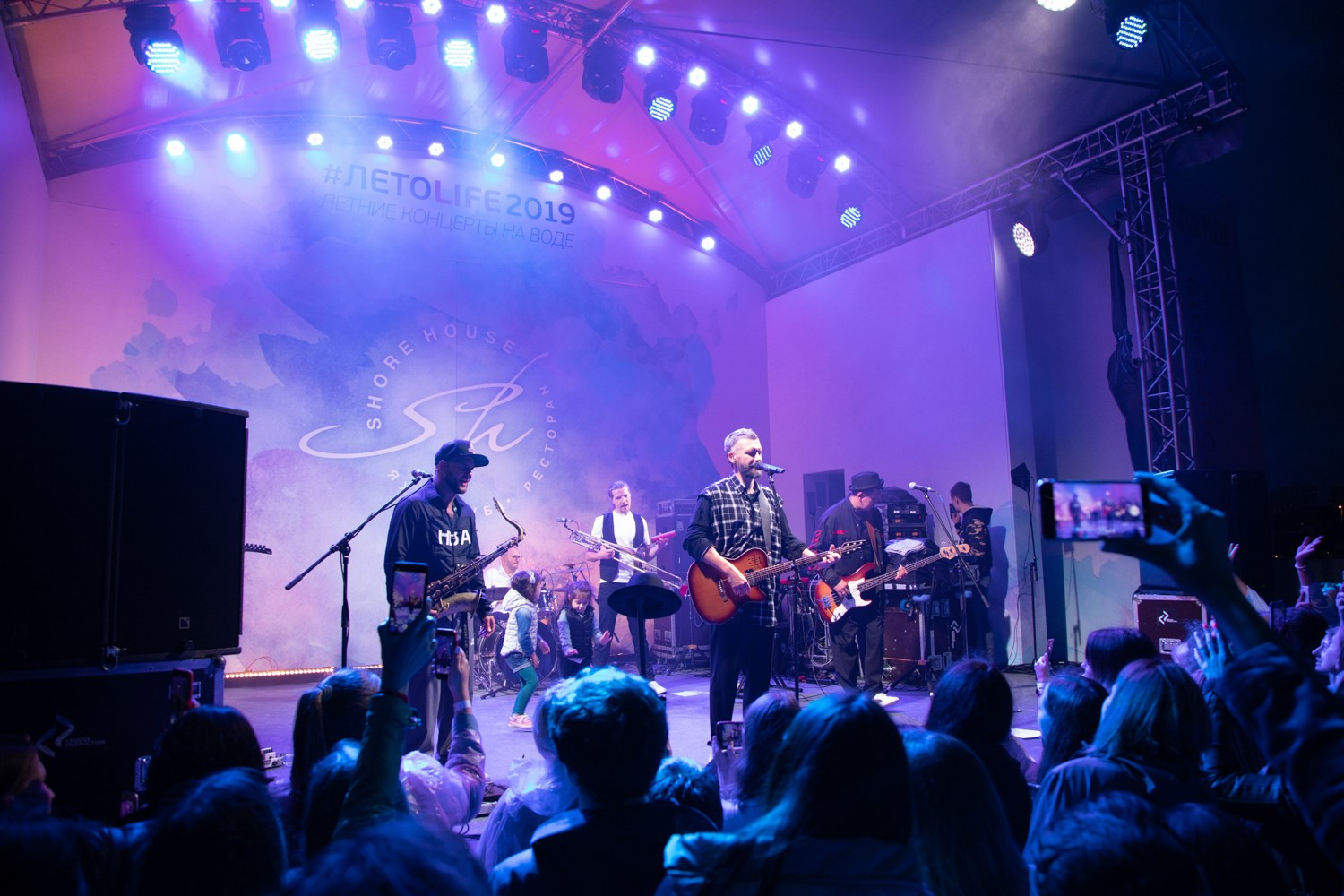 Энергия концерта: музыканты во время выступления, яркий свет и динамика.