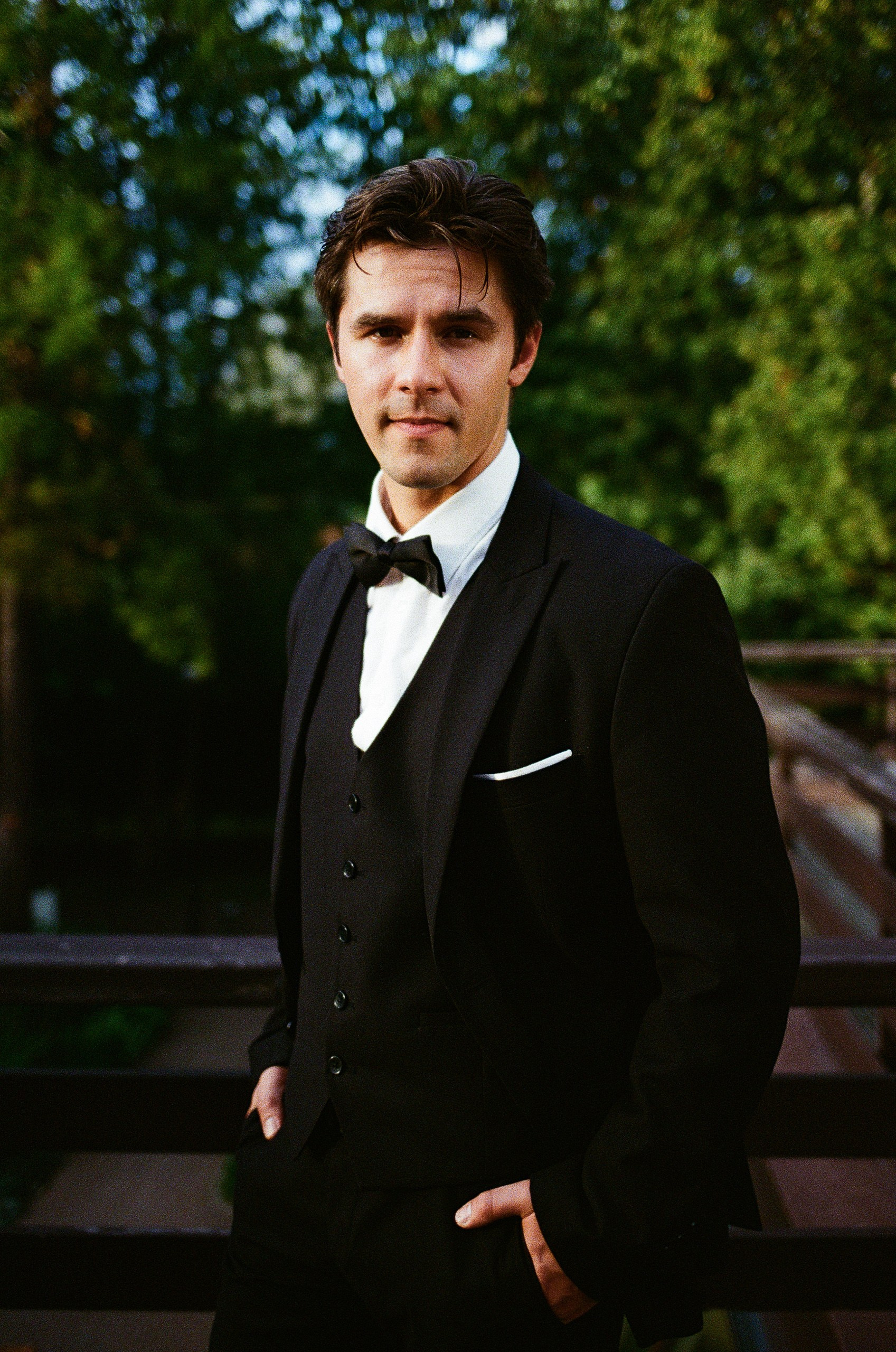 Жених в классическом костюме на фоне зелени, портрет на плёнку