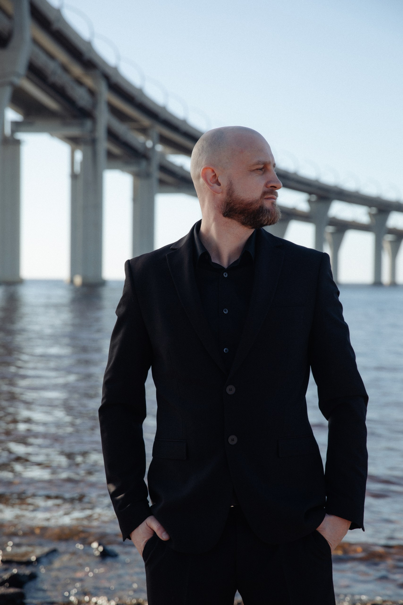 Стильная мужская фотосессия под мостом у воды в Санкт-Петербурге, деловой образ на фоне урбанистики.