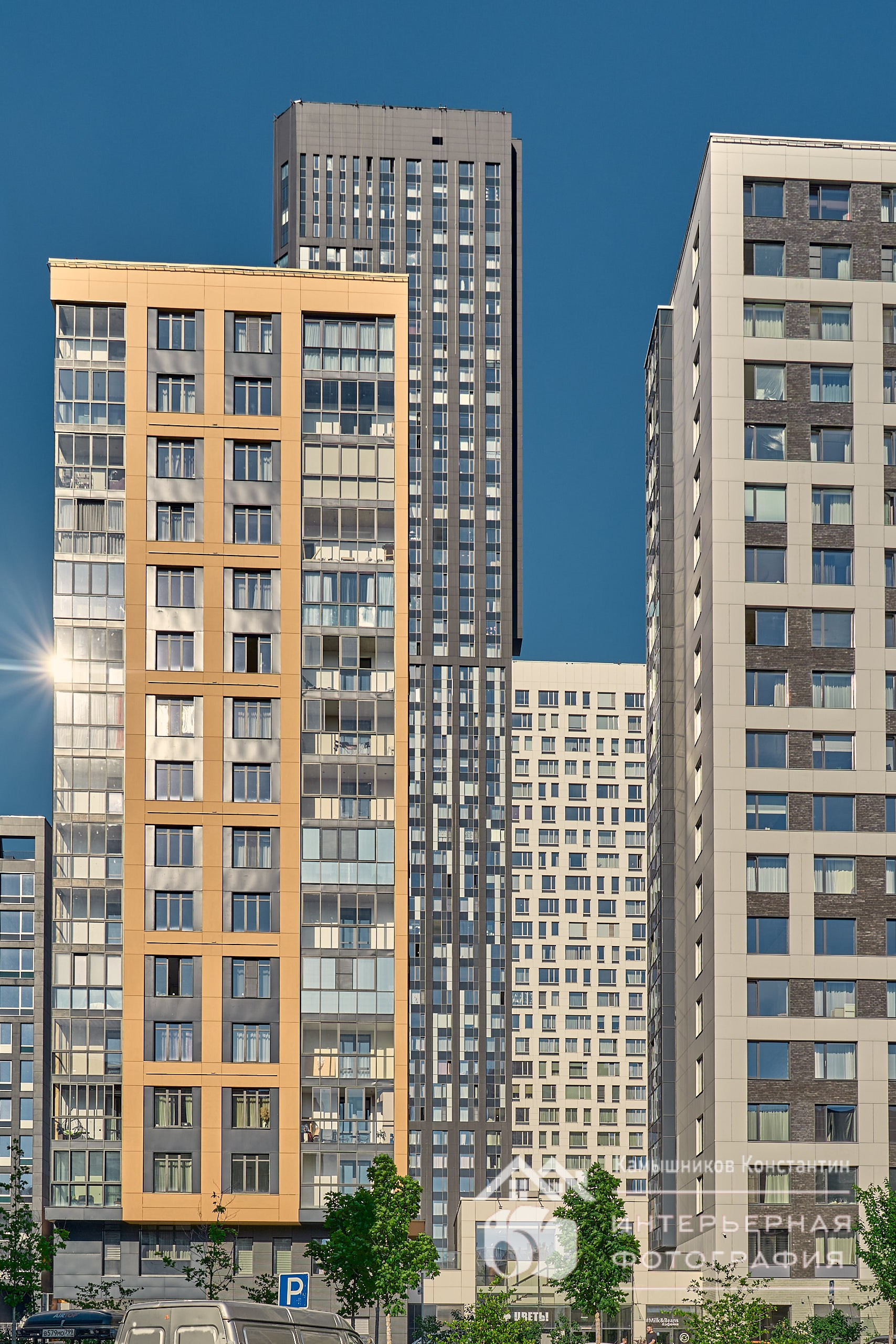 Архитектурная фотография ЖК Headliner от девелопера ГК Кортрос, вид на несколько корпусов, солнечный блик от предзакатного солнца