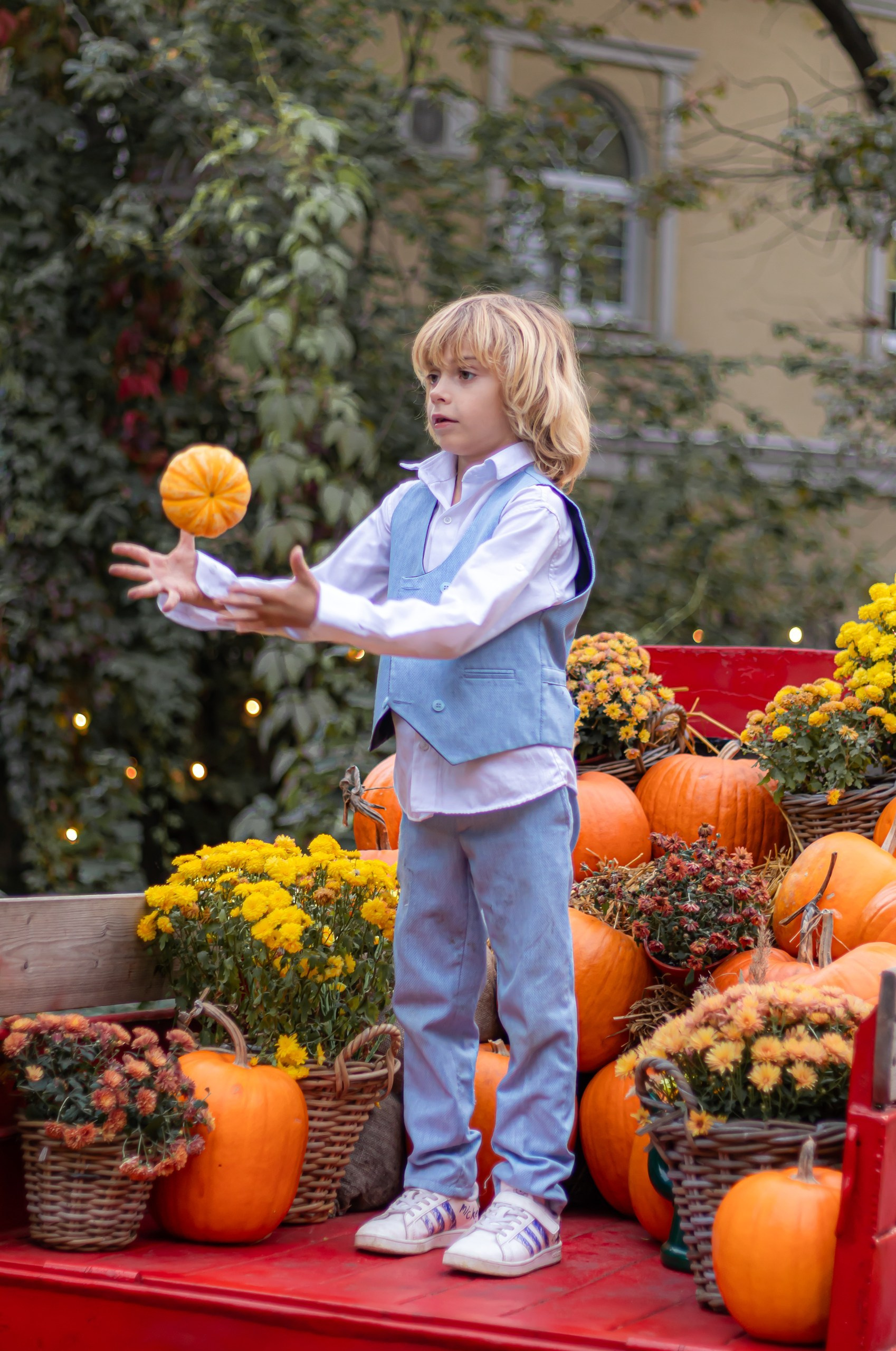 Портрет ребёнка на фоне тыкв и осенних цветов — осенняя фотосессия, фотограф Карасёва Елена