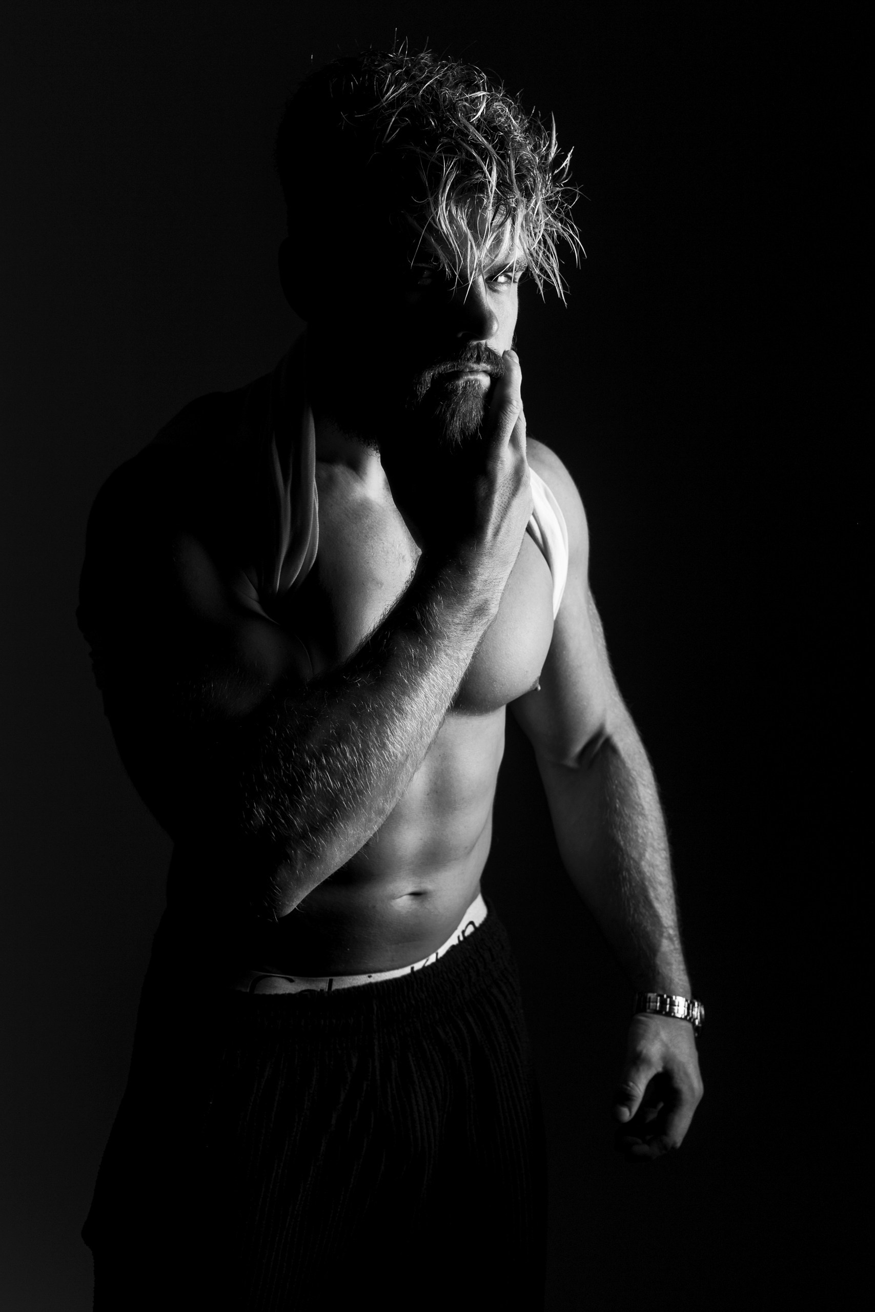 Мужской портрет с напряженными руками за головой, тени на лице и теле — эмоциональная съемка для фитнес-мужчин, Минск