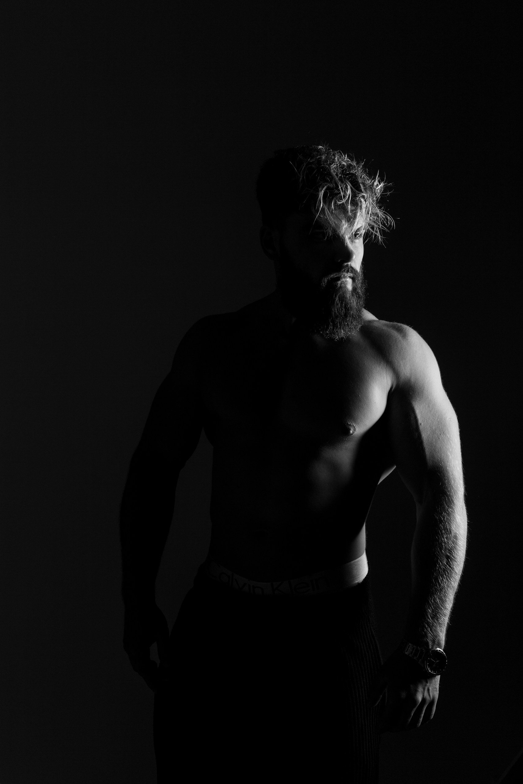 Фотография с низким ракурсом: мощные плечи и грудь, взгляд в камеру — уверенность в каждом кадре, съемка в Минске