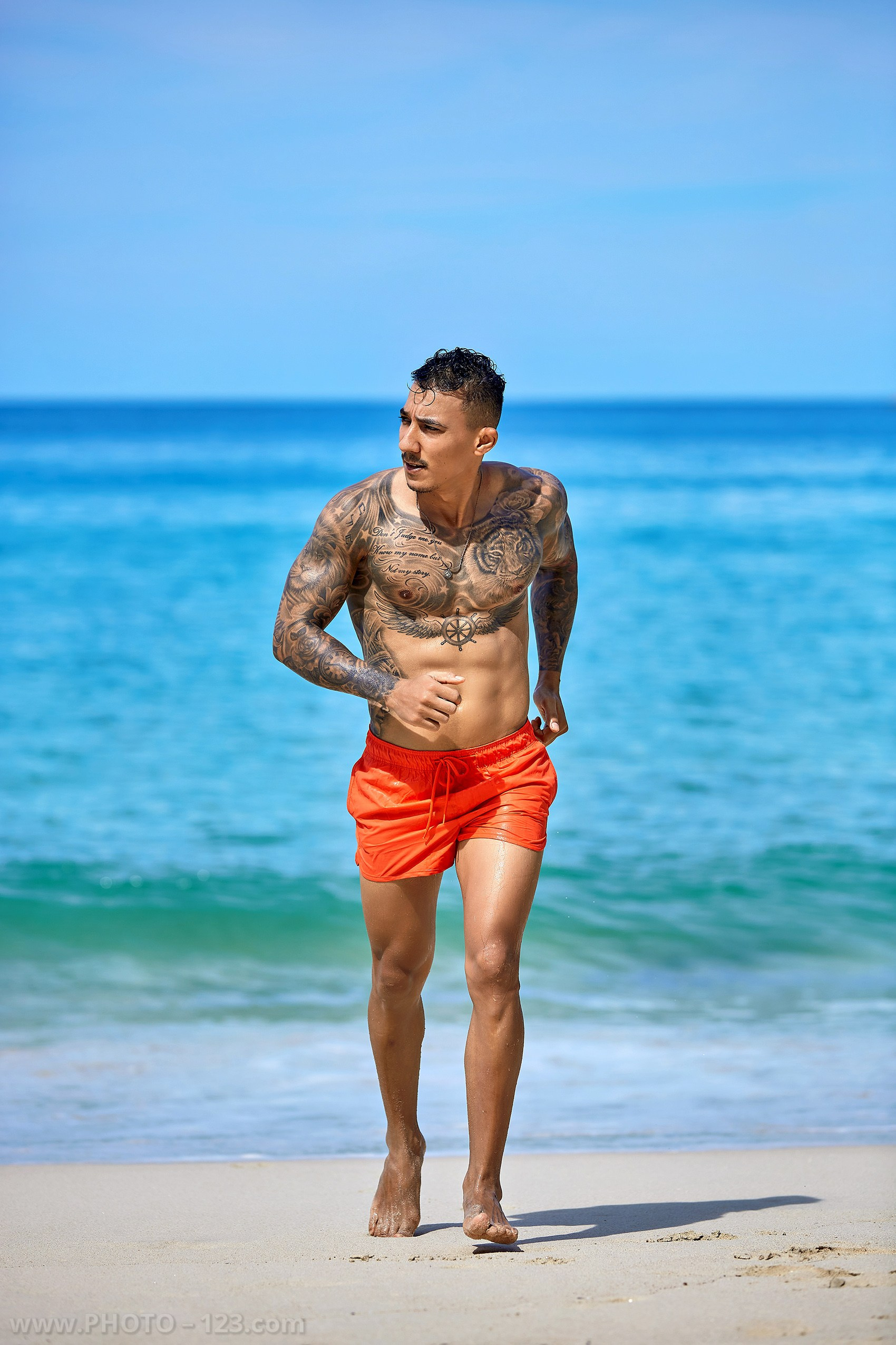 Fitness male model jogging along the ocean shoreline during a portrait session in Nha Trang Vietnam