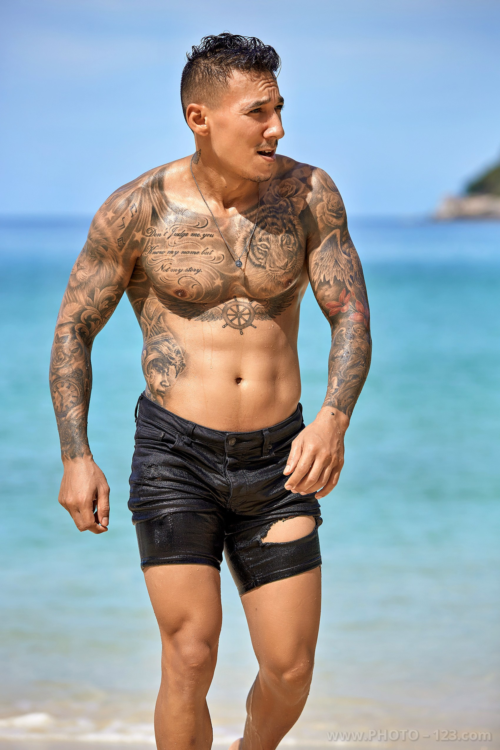 Muscular man walking along the tropical beach shore during a male portrait session in Nha Trang Vietnam